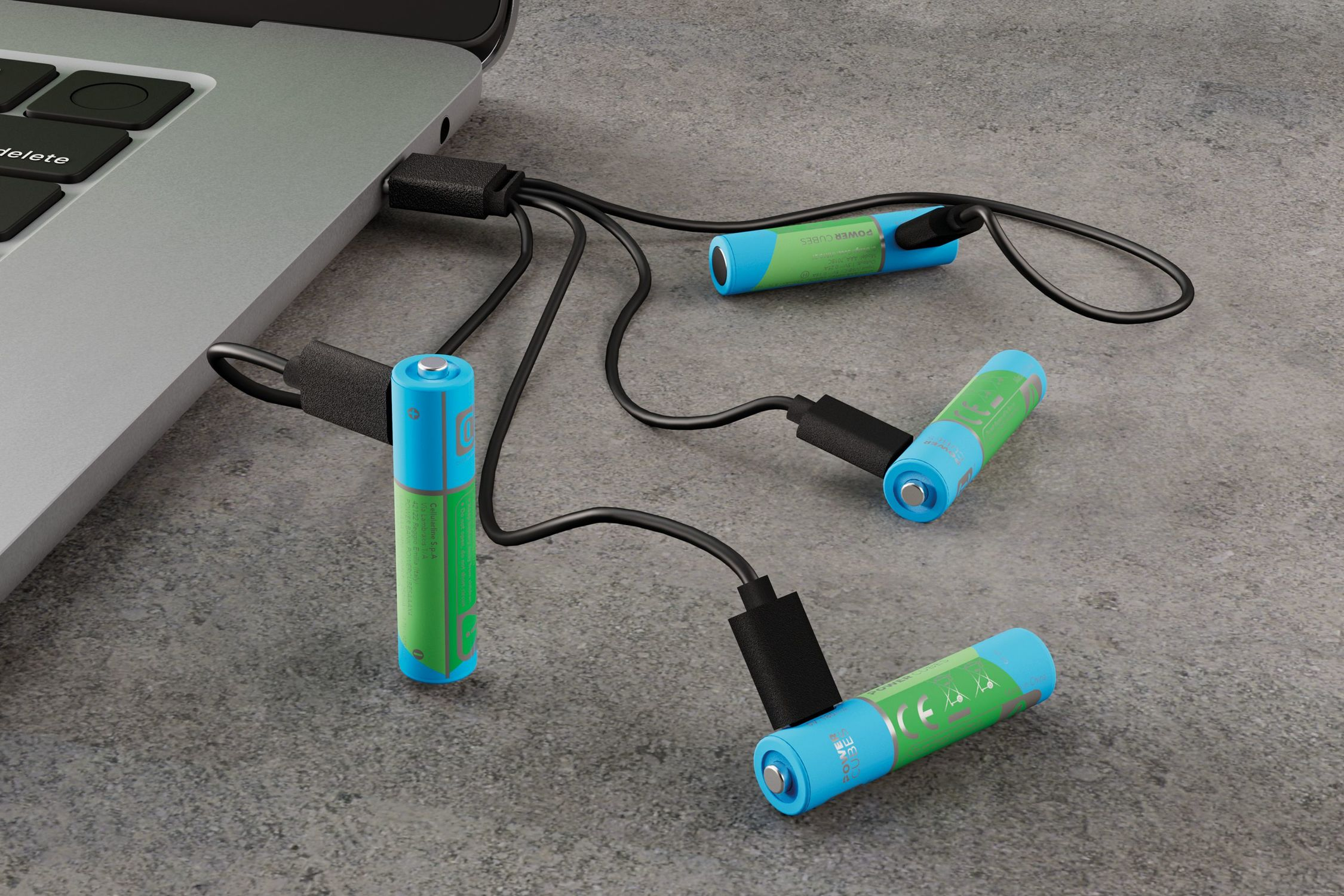 Cuatro pilas AA se cargan mediante cables USB conectados a un portátil.