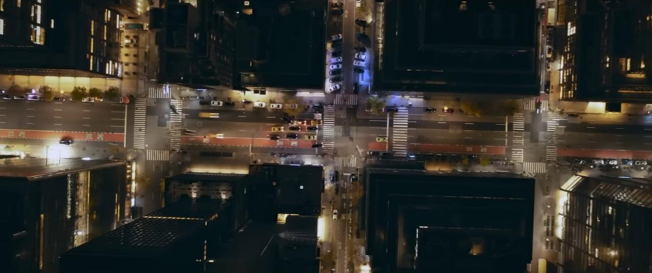 Nachtsicht einer Stadt mit Autos auf beleuchteten Straßen und Gebäuden.