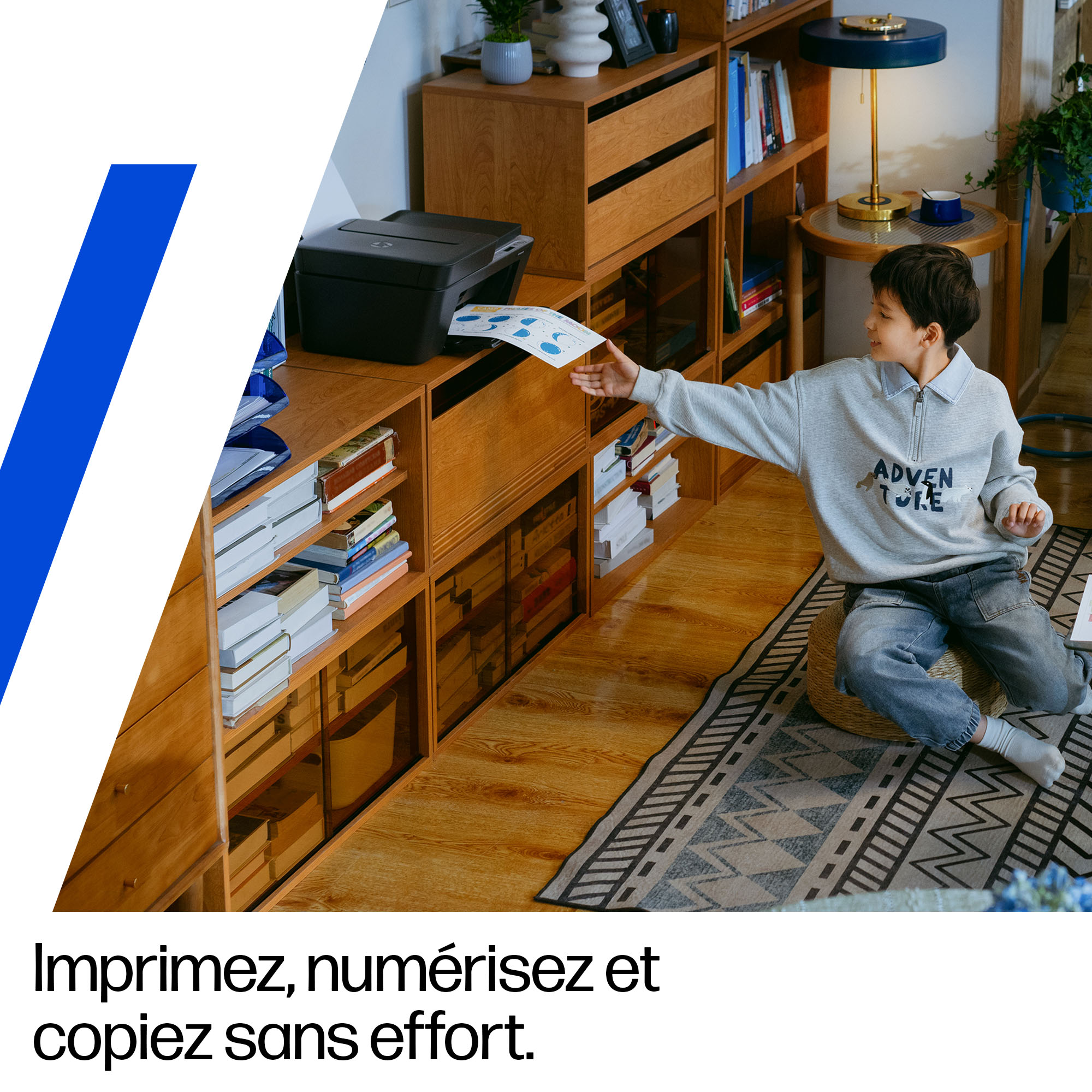 Un garçon retire une feuille d'une imprimante.
