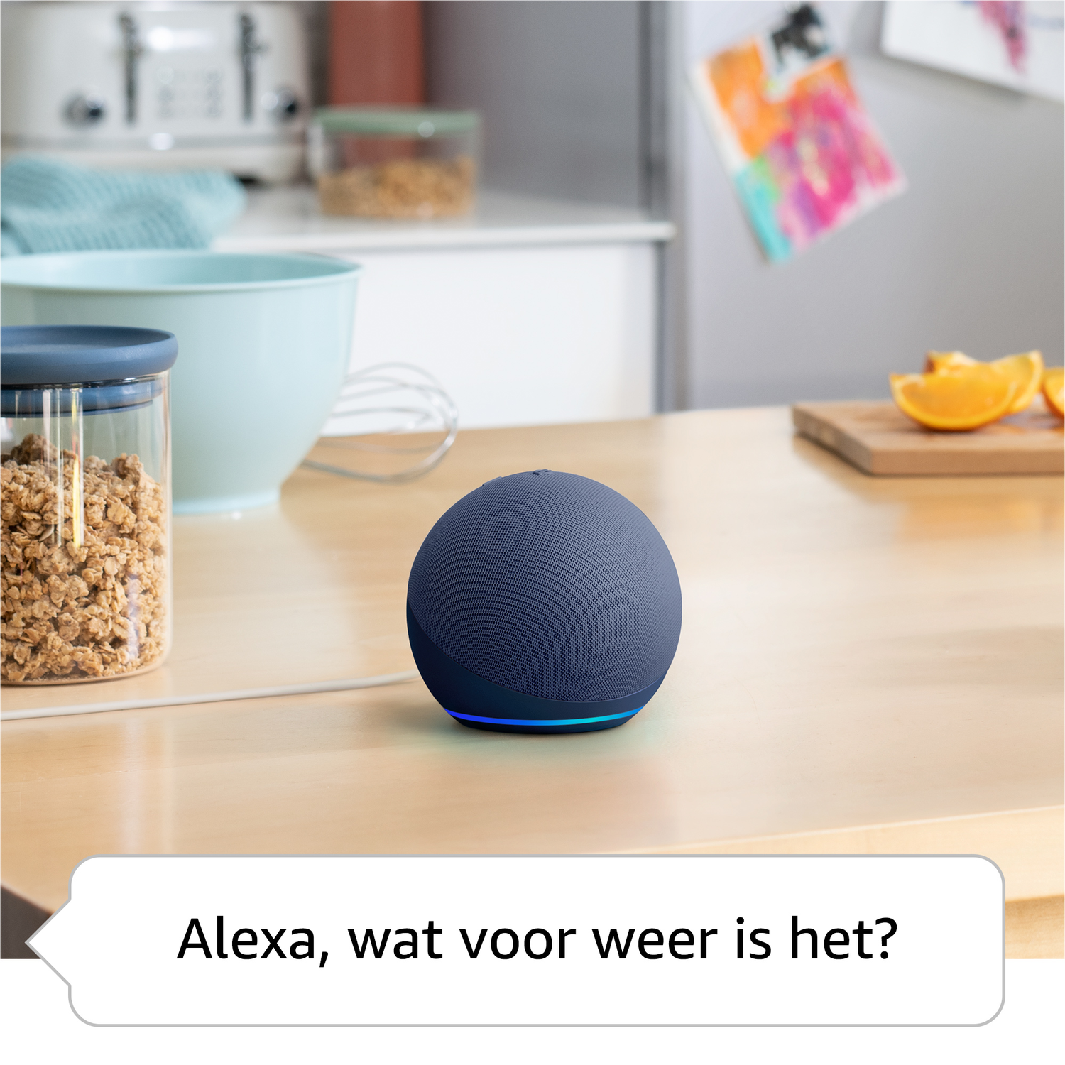 A blue Echo Dot sits on a wooden table near a bowl of cereal and oranges.