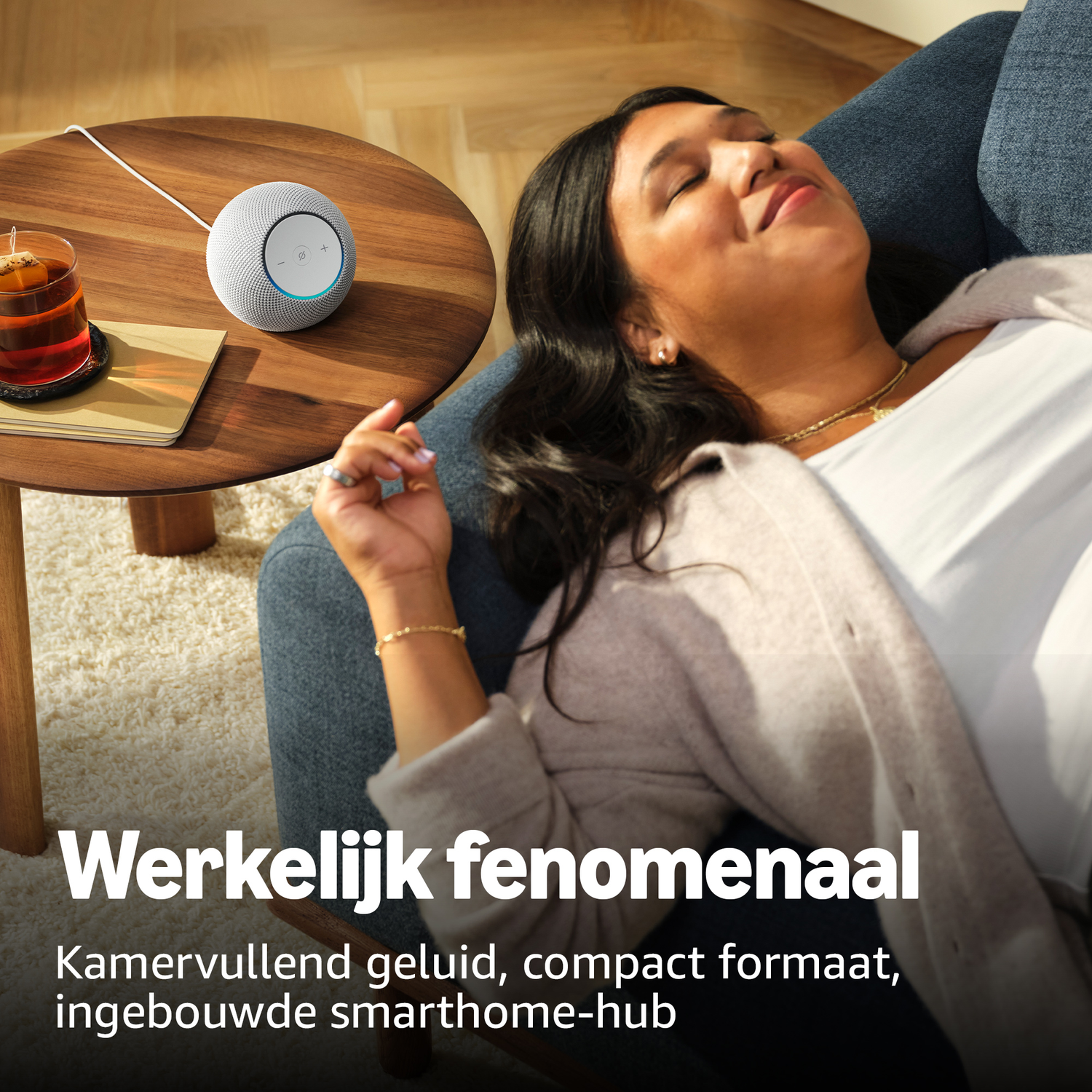 Woman relaxing on sofa, smart speaker and tea on wooden table.