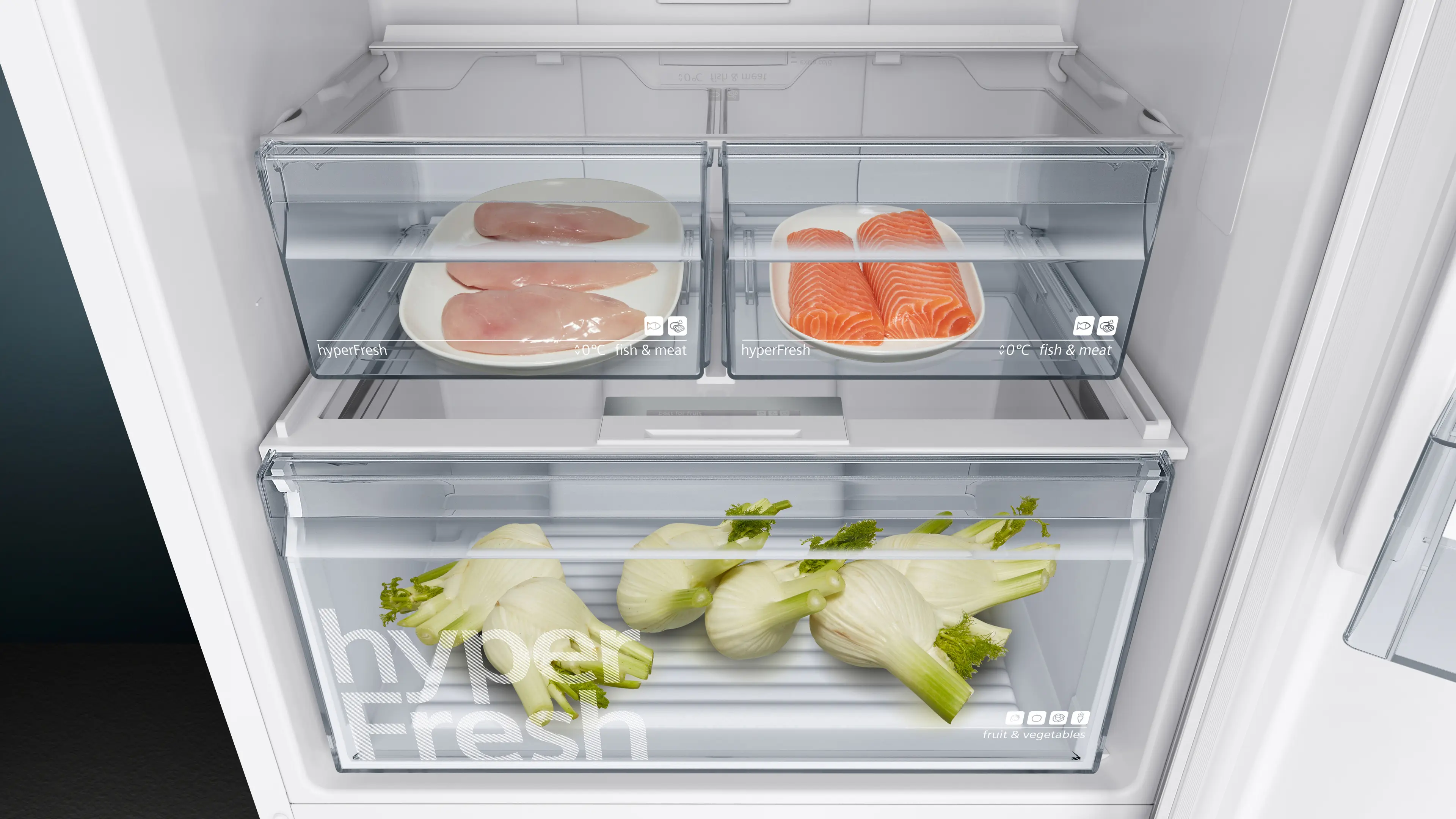 Cajones del refrigerador con pollo crudo, salmón y hinojo.