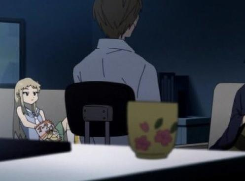 Mädchen isst Snacks, Mann sitzt am Tisch mit einer Tasse.