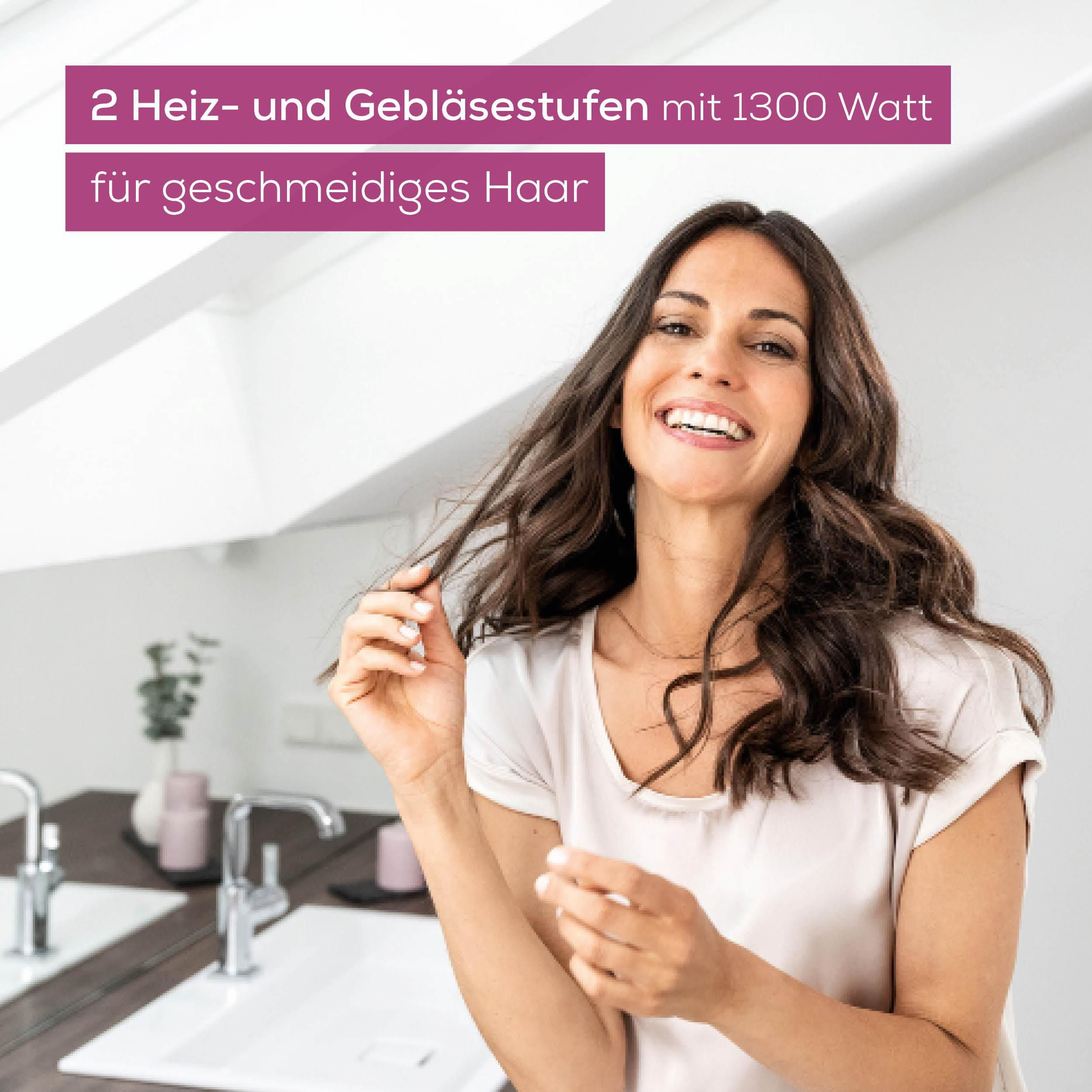 Frau mit langen braunen Haaren lacht und berührt ihr Haar. Text sagt 1300 Watt.