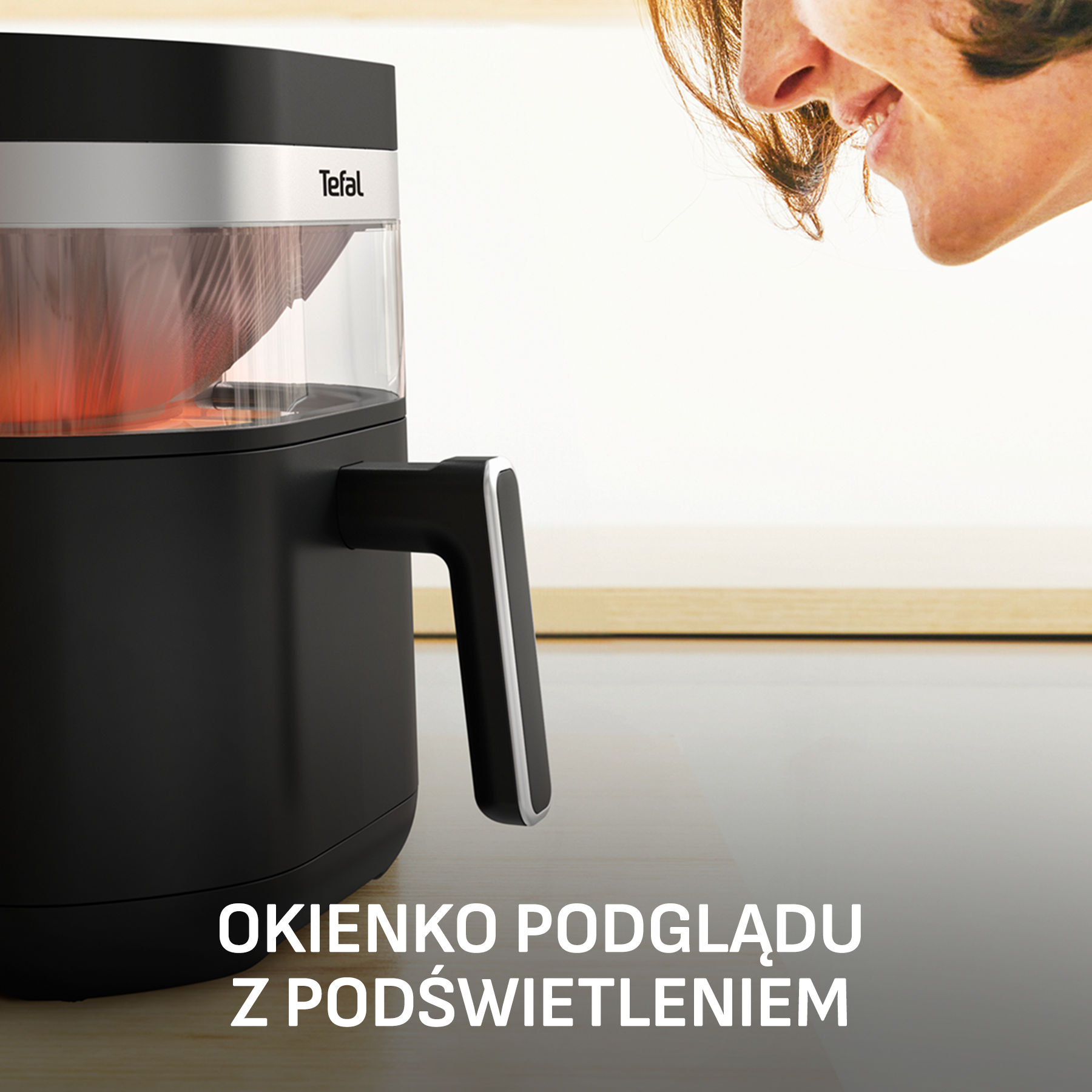 Czarna frytkownica Tefal z podświetlanym okienkiem i częścią twarzy.