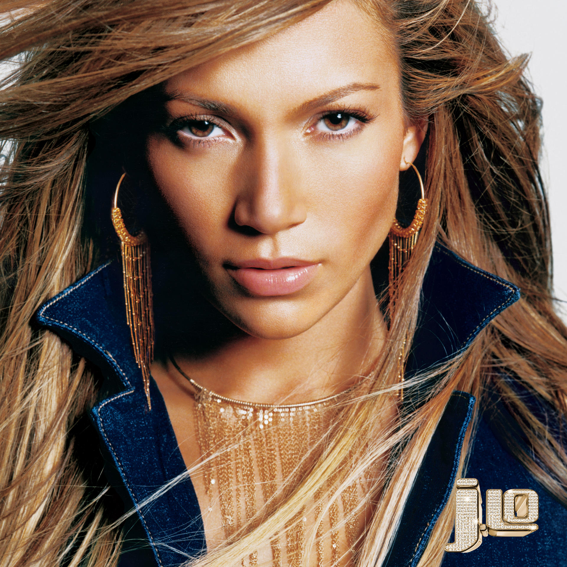Nahaufnahme von Jennifer Lopez mit langen blonden Haaren, Goldohrringen und Jeansjacke.