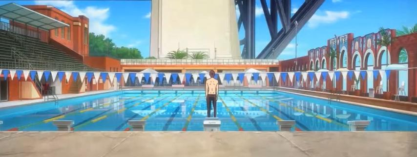 Ein einzelner Schwimmer steht auf einem Startblock an einem leuchtend blauen Schwimmbecken.
