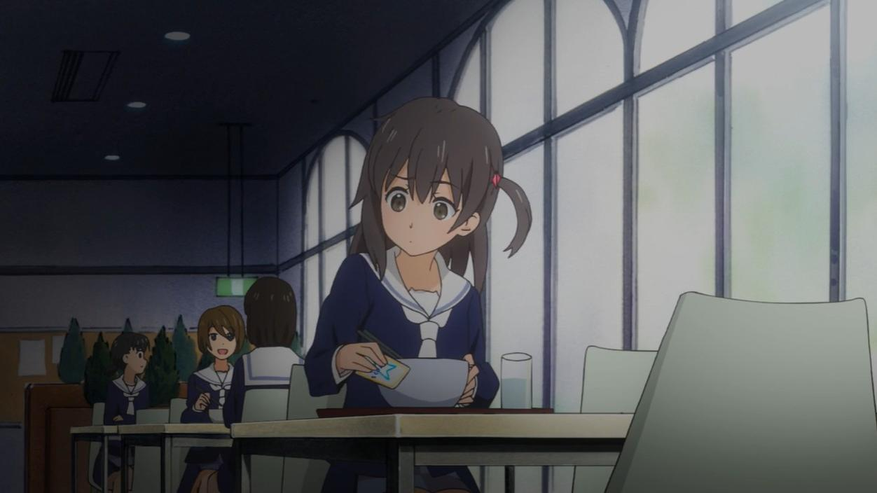 Ein Mädchen in Schuluniform isst in einem Speisesaal. Andere Schüler sind im Hintergrund.