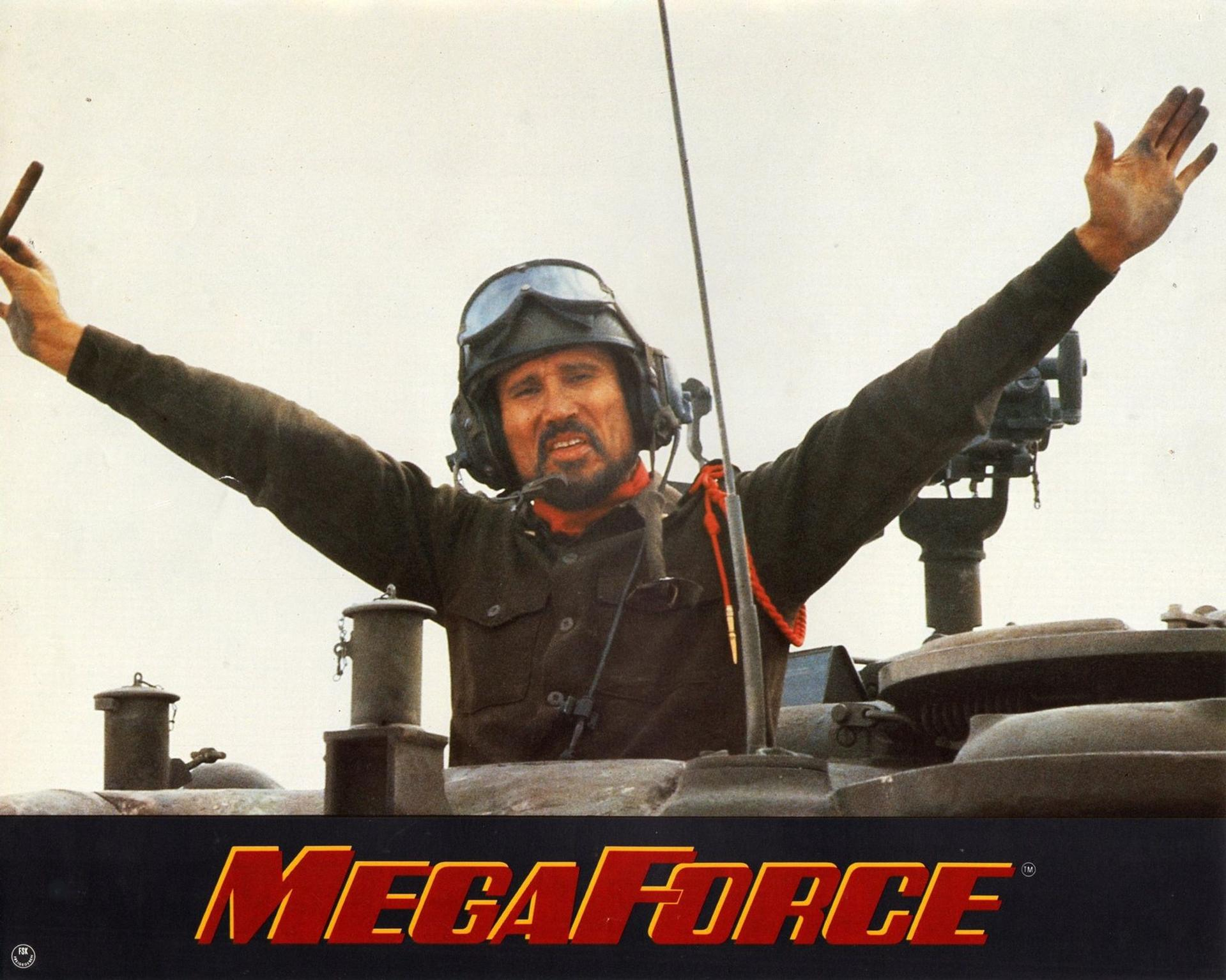 Mann in Panzer mit erhobenen Armen und Zigarre. Megaforce-Logo unten.