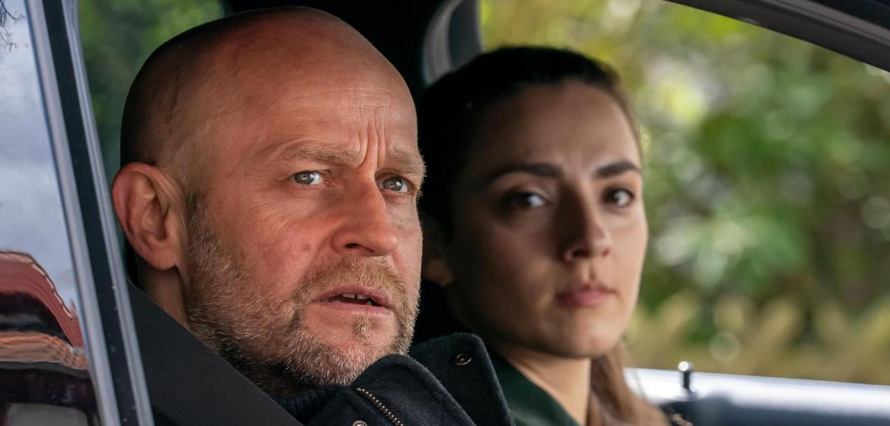 Ein Mann und eine Frau sitzen im Auto, sie blicken nachdenklich.