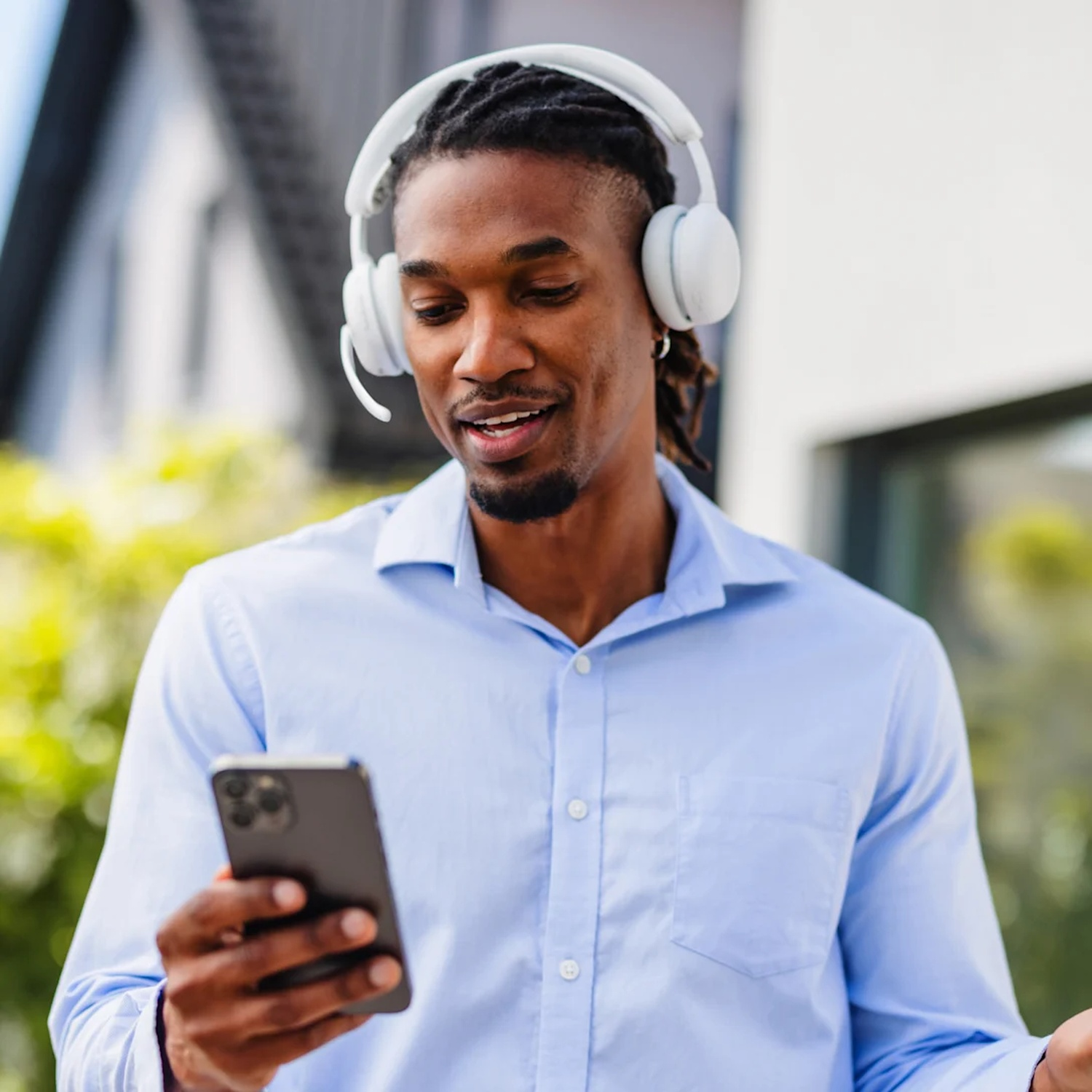 Un homme portant un casque regarde son téléphone.