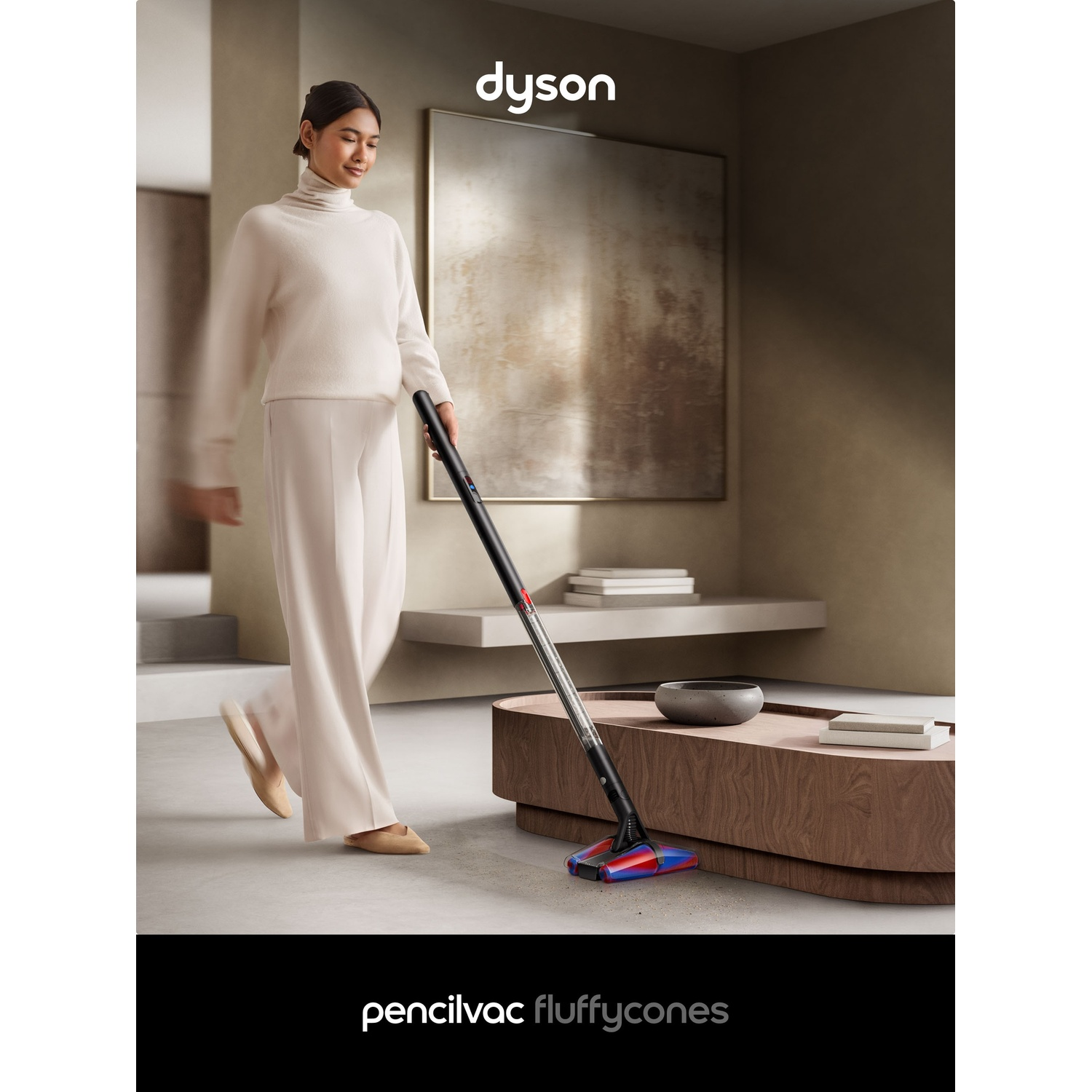 Una donna aspira un pavimento in legno in un soggiorno con un aspirapolvere Dyson.