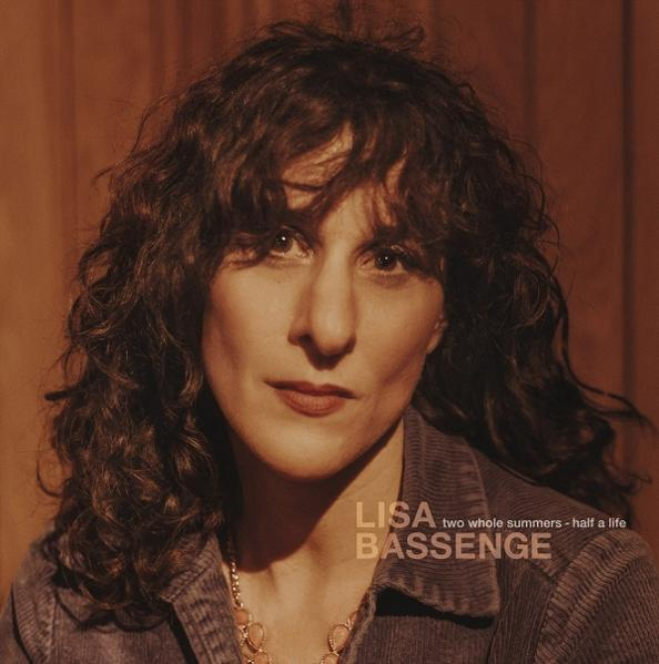Lisa Bassenge, eine Frau mit lockigen dunklen Haaren, vor braunem Hintergrund.