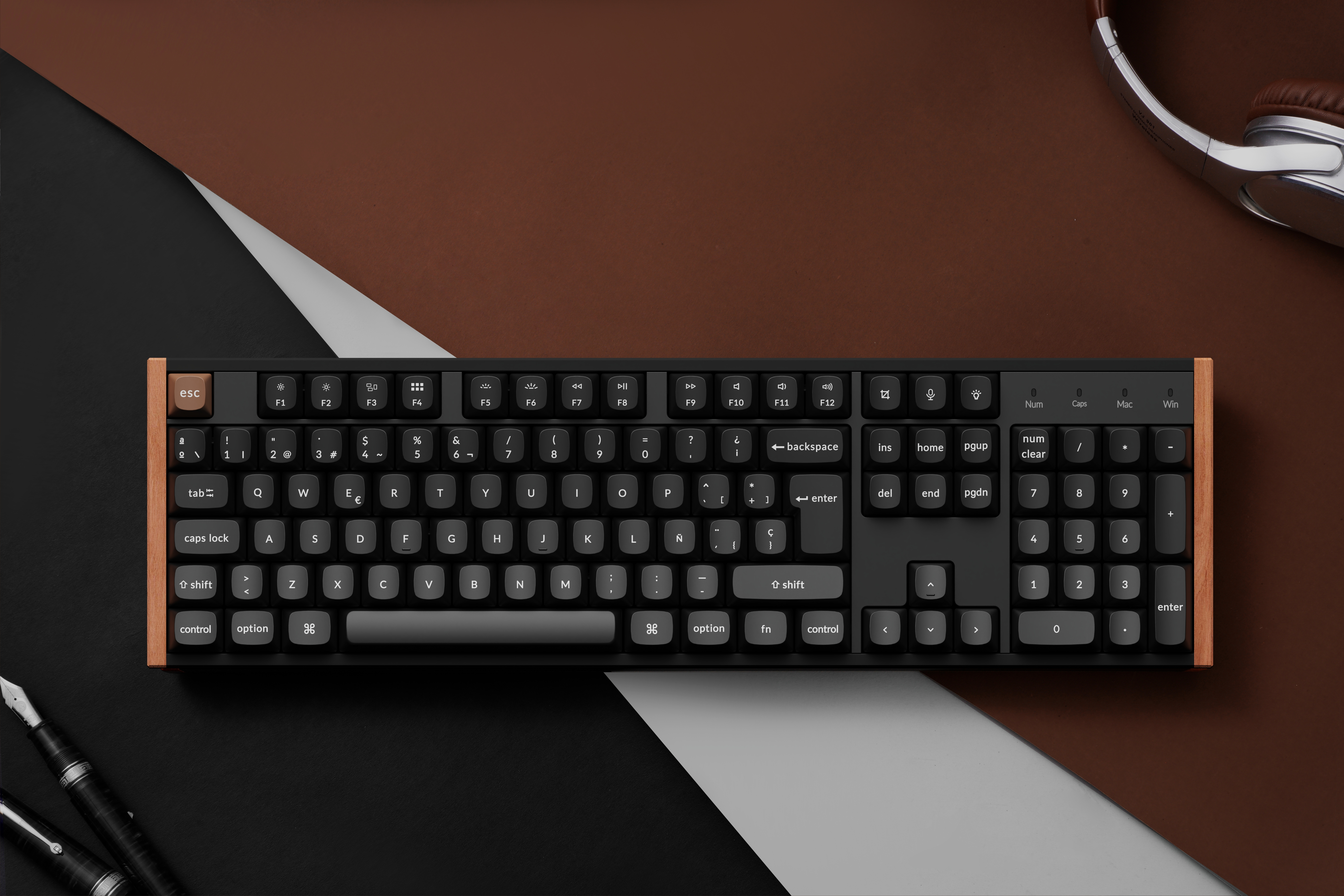 Eine Tastatur mit Holzrahmen liegt auf einem braunen und schwarzen Hintergrund.