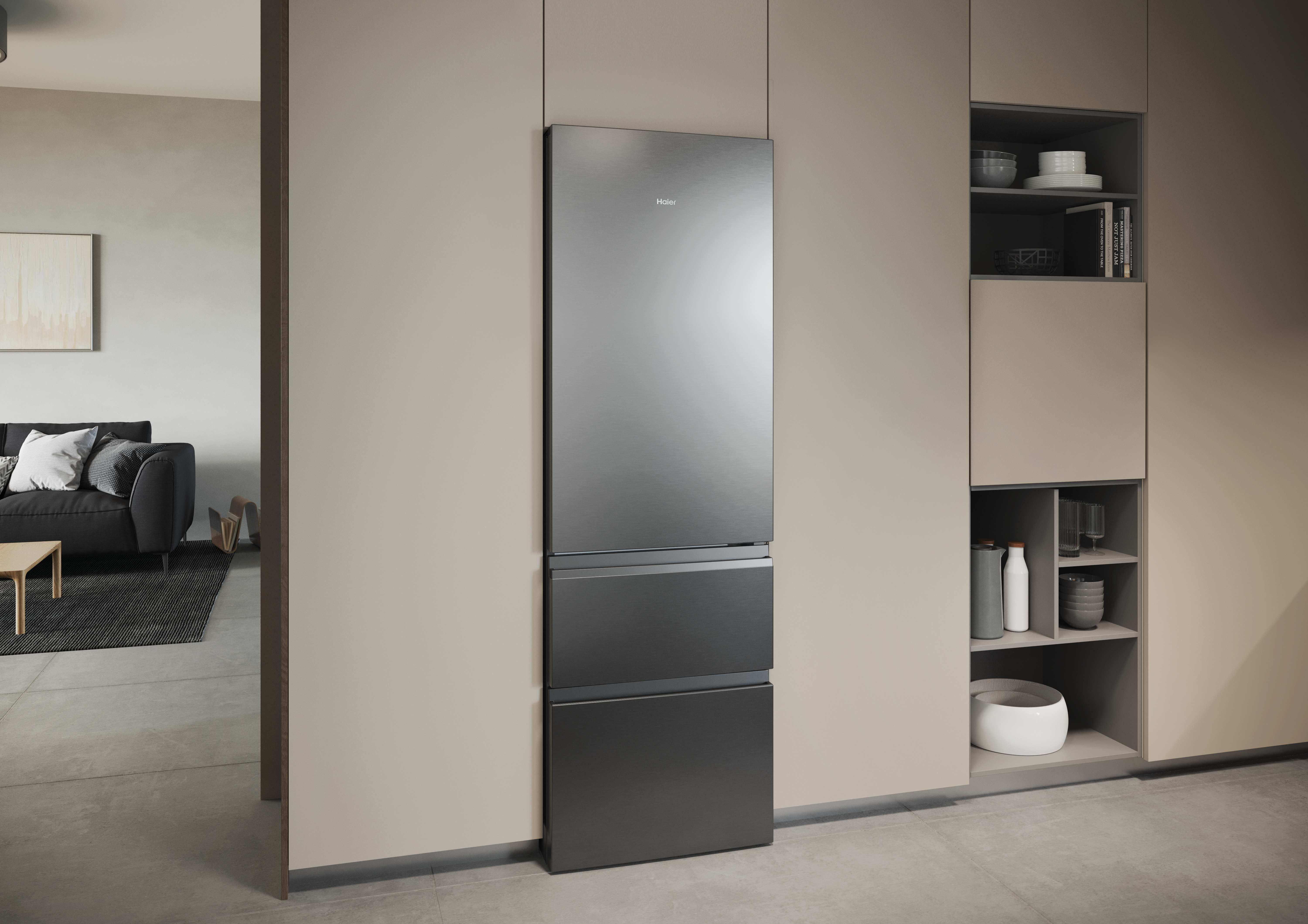 Ein moderner silberner Kühlschrank mit drei Schubladen neben einem offenen Regal mit Geschirr.