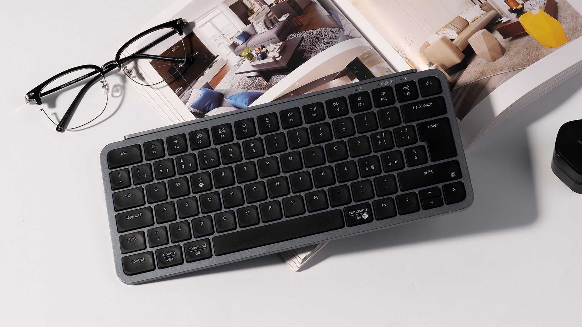 Eine Brille und eine Tastatur liegen auf einem geöffneten Magazin.