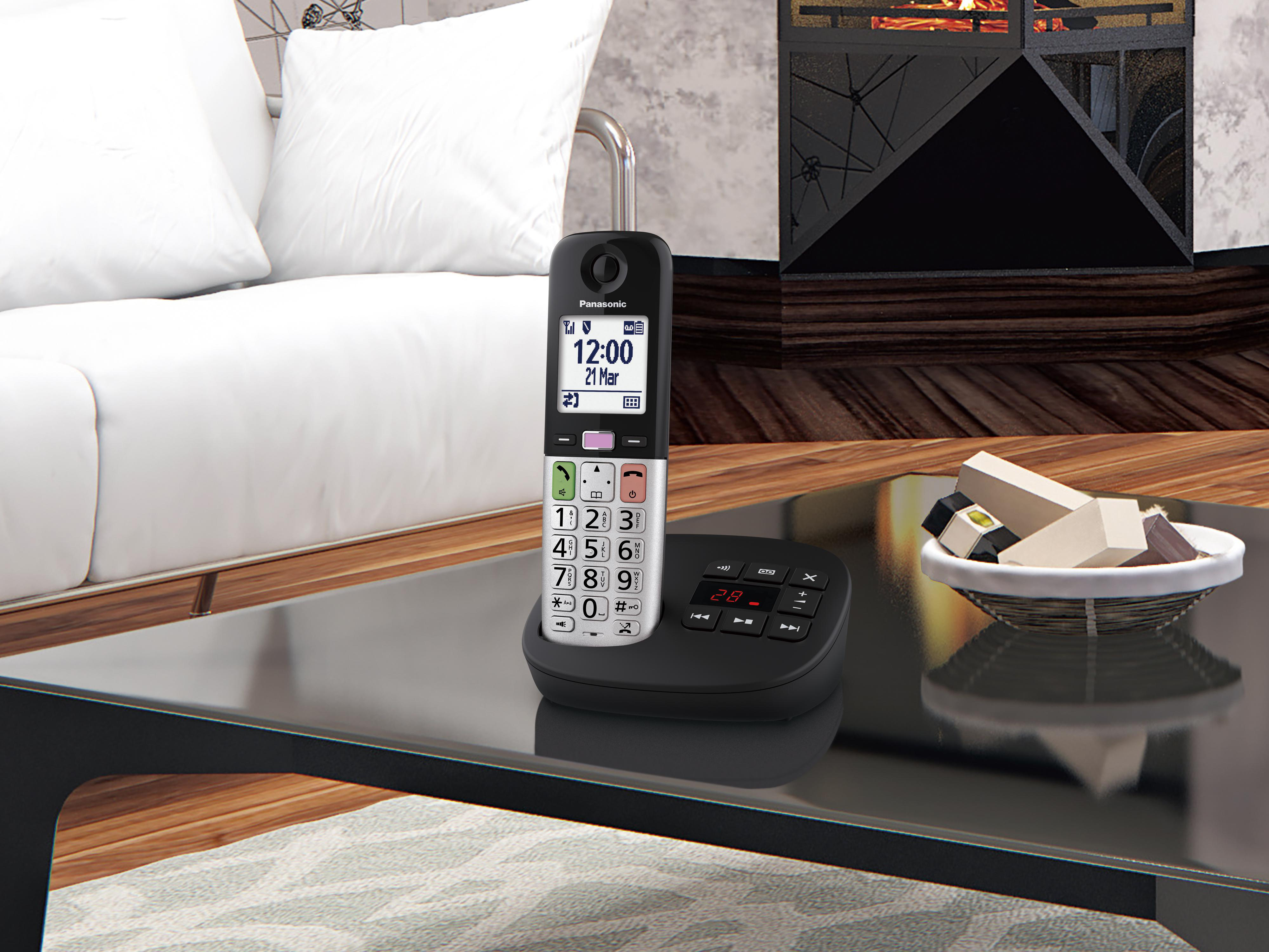 Ein schwarzes schnurloses Panasonic-Telefon steht auf einem Tisch vor einem Kamin.