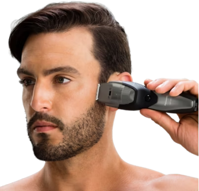 Un homme se rase la barbe avec un rasoir électrique.