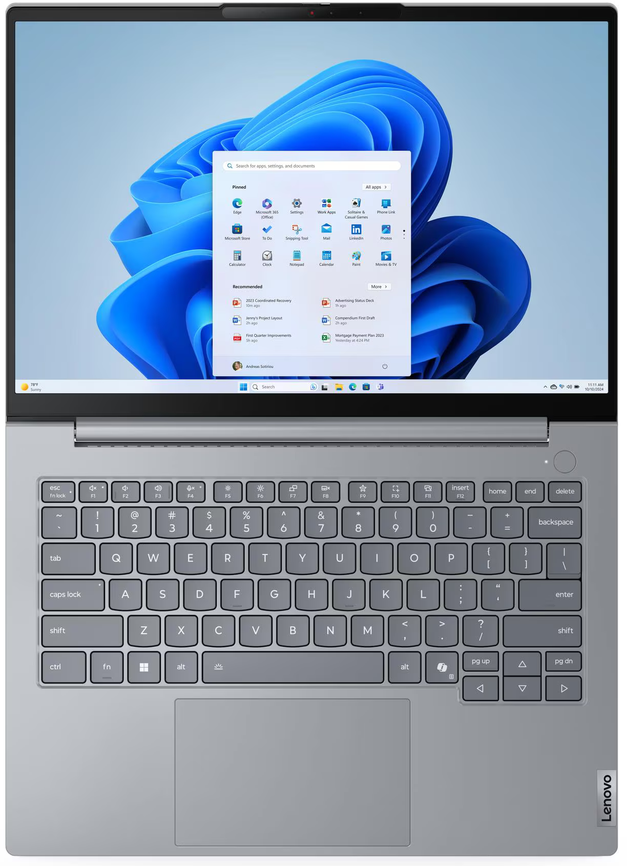 Egy szürke laptop, amelyen kék hullámokat ábrázoló Windows 11 indítómenü látható.