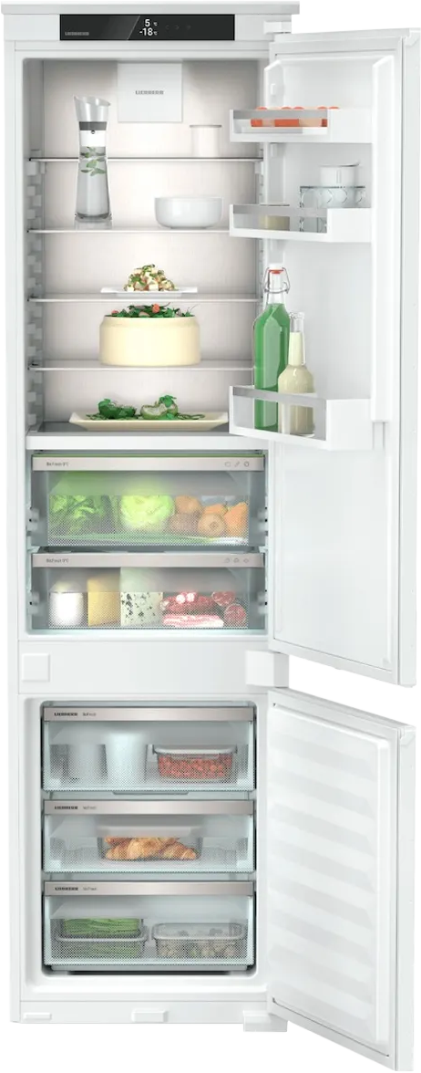 Ein offener weißer Kühlschrank mit Lebensmitteln auf den Regalen und in den Schubladen.