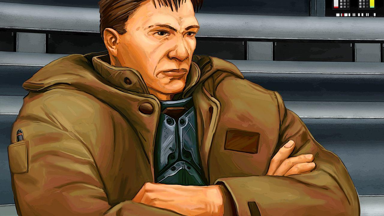 Mann in brauner Jacke mit verschränkten Armen sitzt vor grauer Kulisse.