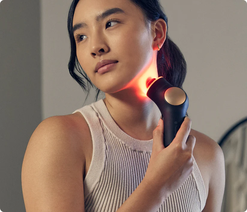 Mujer usa dispositivo de cuidado de la piel con luz roja en el cuello.