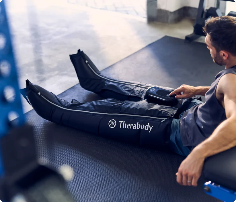 Hombre usando botas de compresión en un gimnasio.