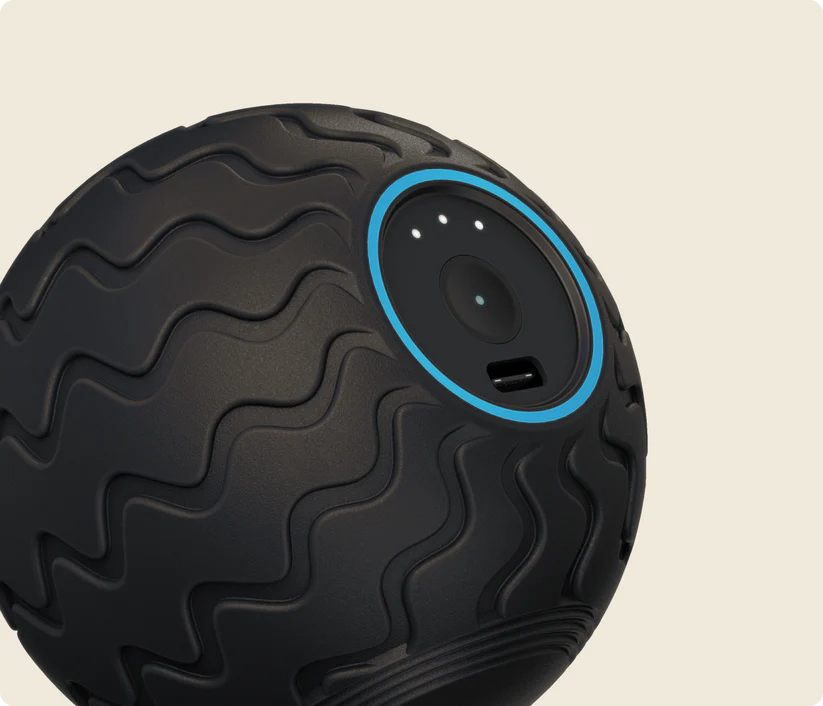 Pelota de masaje negra texturizada con anillo azul alrededor de una hendidura circular con luces.
