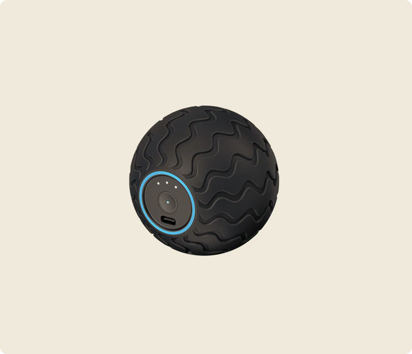 Pelota de masaje negra con patrón de olas y anillo azul, con puerto de carga.