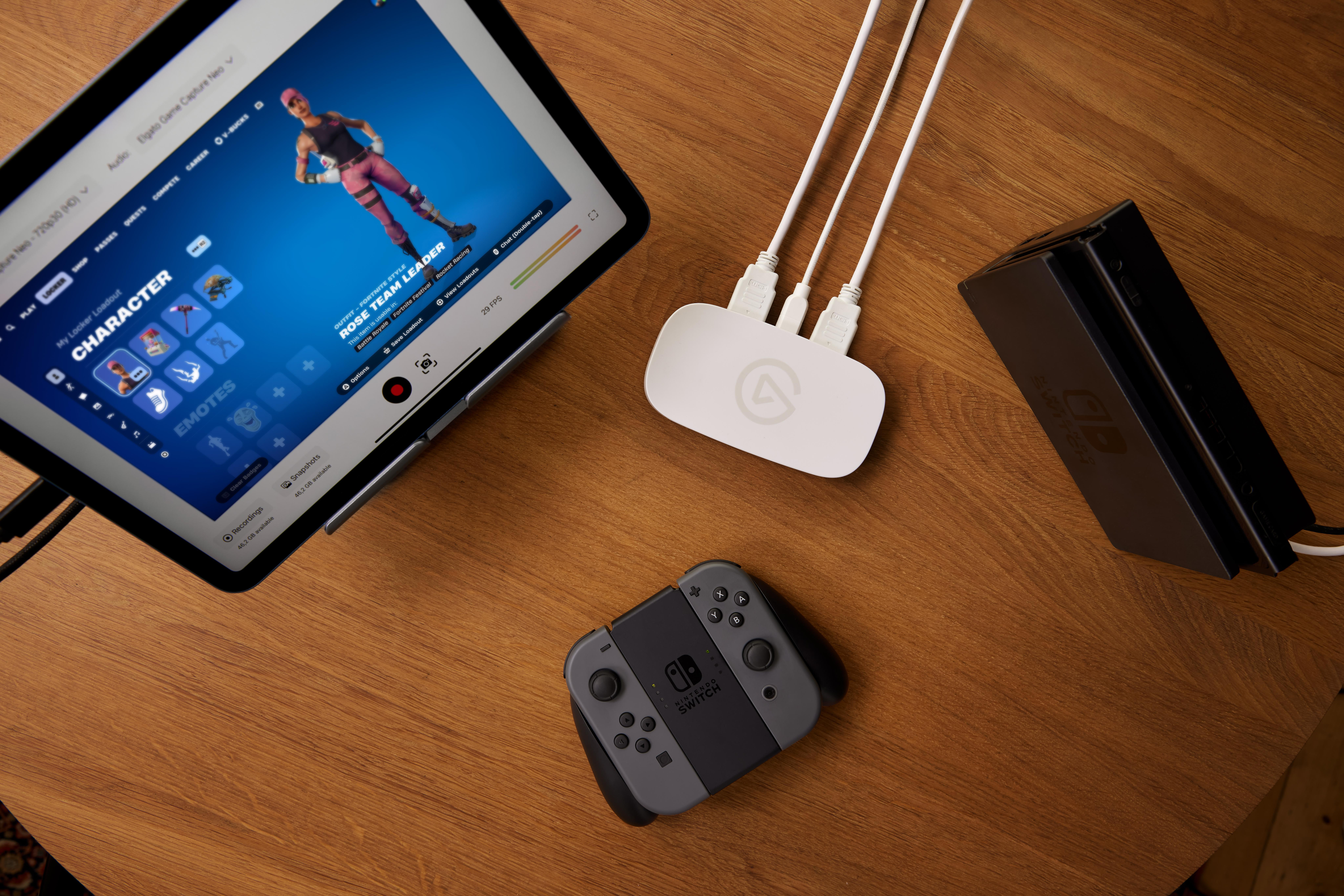 Ein Tablet zeigt Fortnite, daneben ein Nintendo Switch Controller und eine Dockingstation.