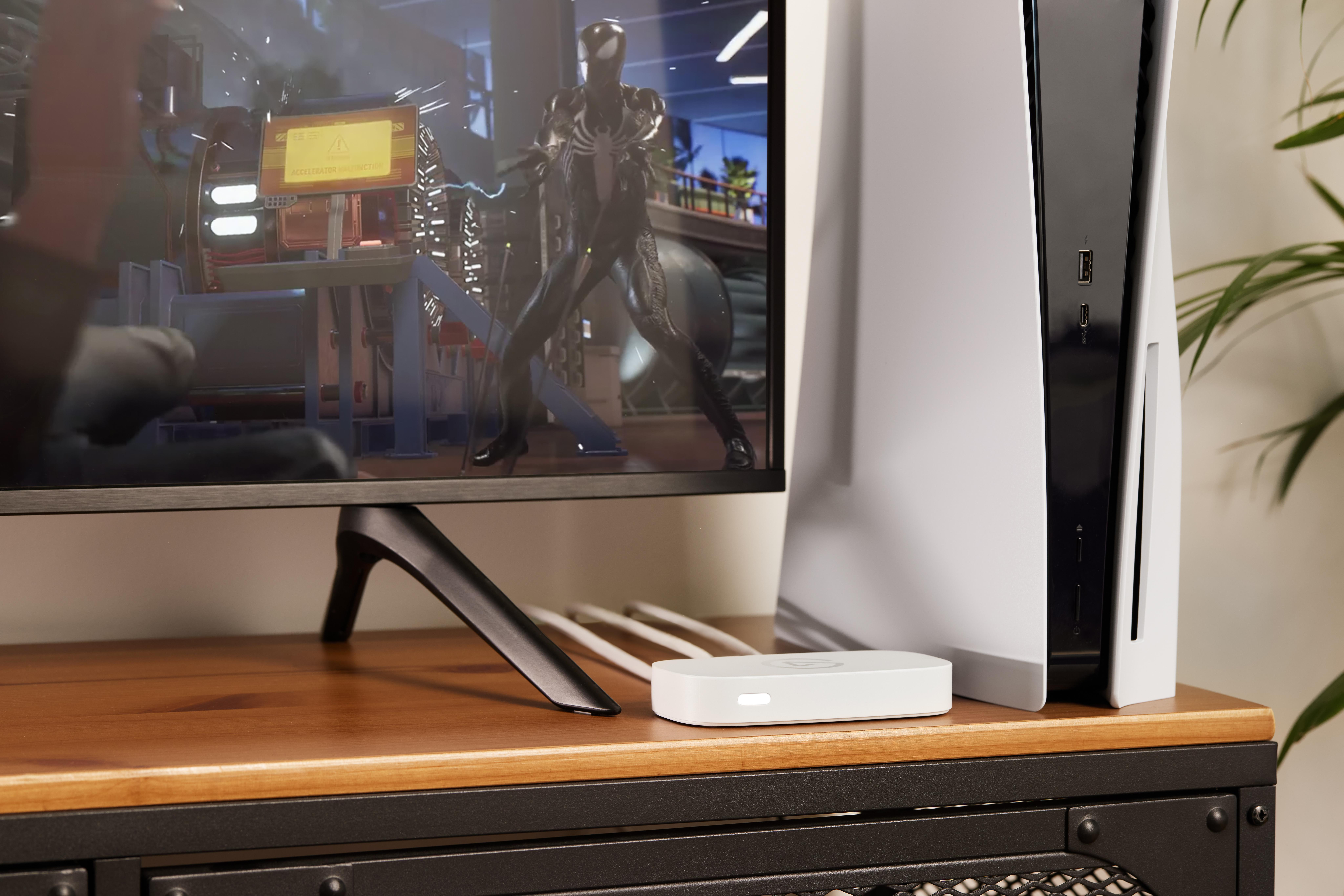 PlayStation 5 neben einem Monitor mit Spiderman-Spiel.