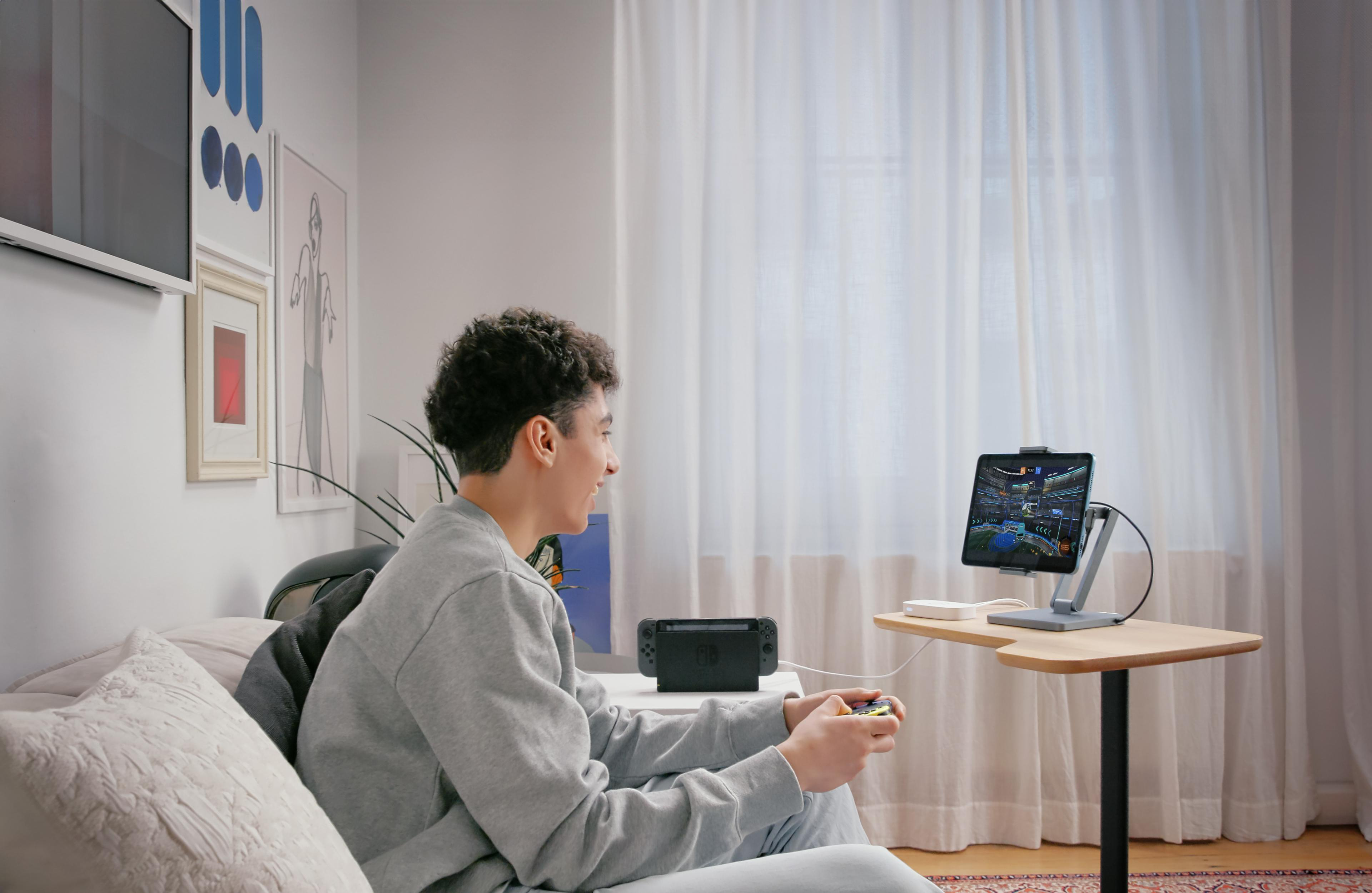Junge spielt Nintendo Switch auf einem Tablet mit Controller in einem gemütlichen Zimmer.