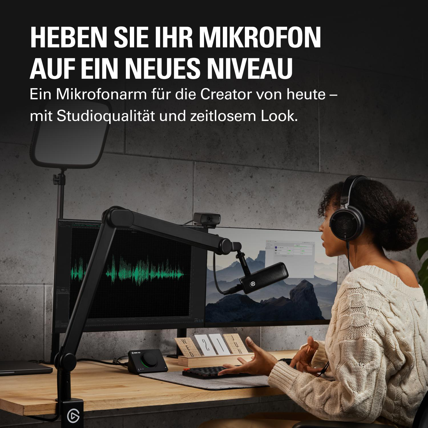 Eine Frau mit Kopfhörern sitzt am Schreibtisch, umgeben von Technik.