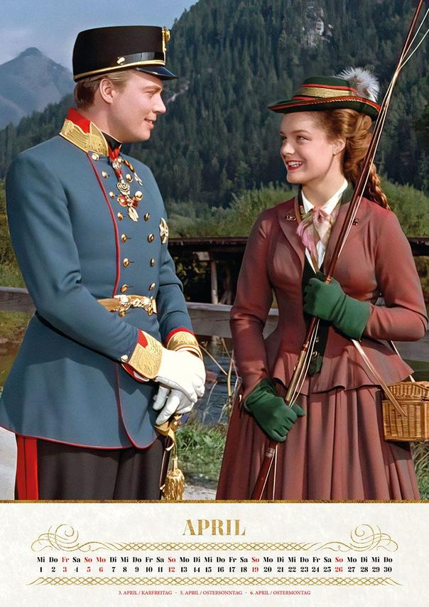Ein Mann in blauer Uniform und eine Frau mit Pfeil und Bogen stehen draußen.