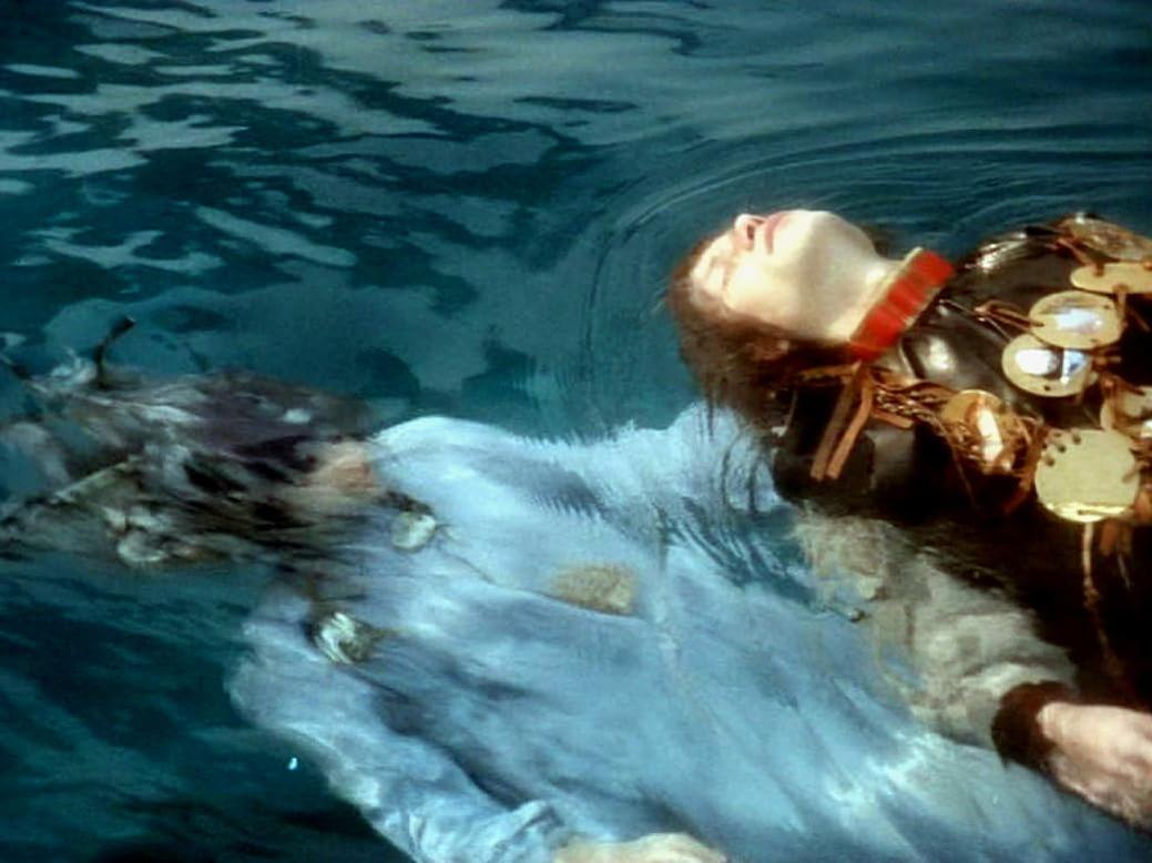 Eine Person treibt auf dem Rücken in blauem Wasser, mit dem Gesicht nach oben und geschlossenen Augen.