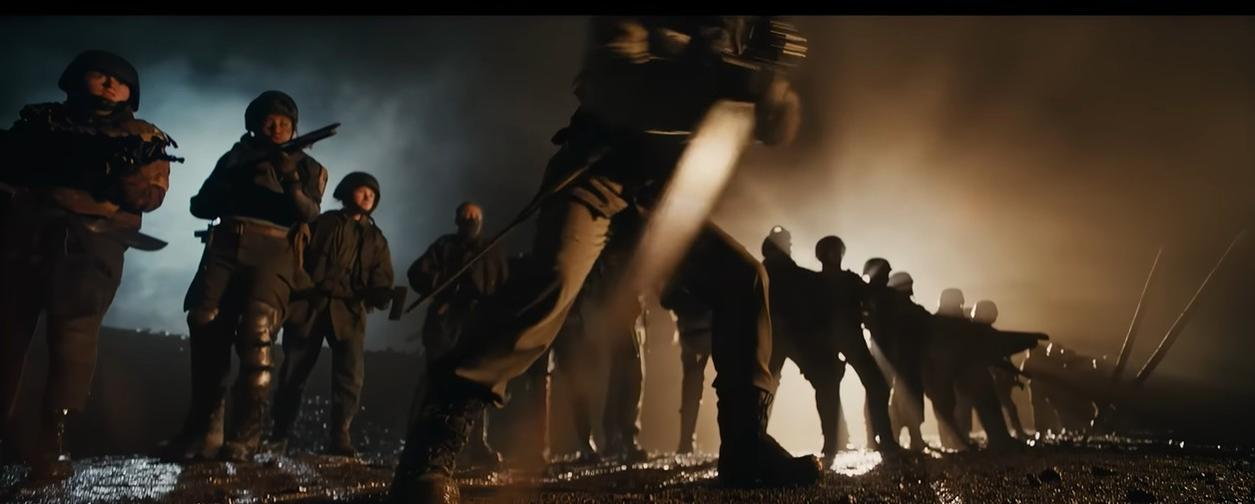 Soldaten in Uniformen stehen im Nebel, bewaffnet mit Gewehren und Messern.
