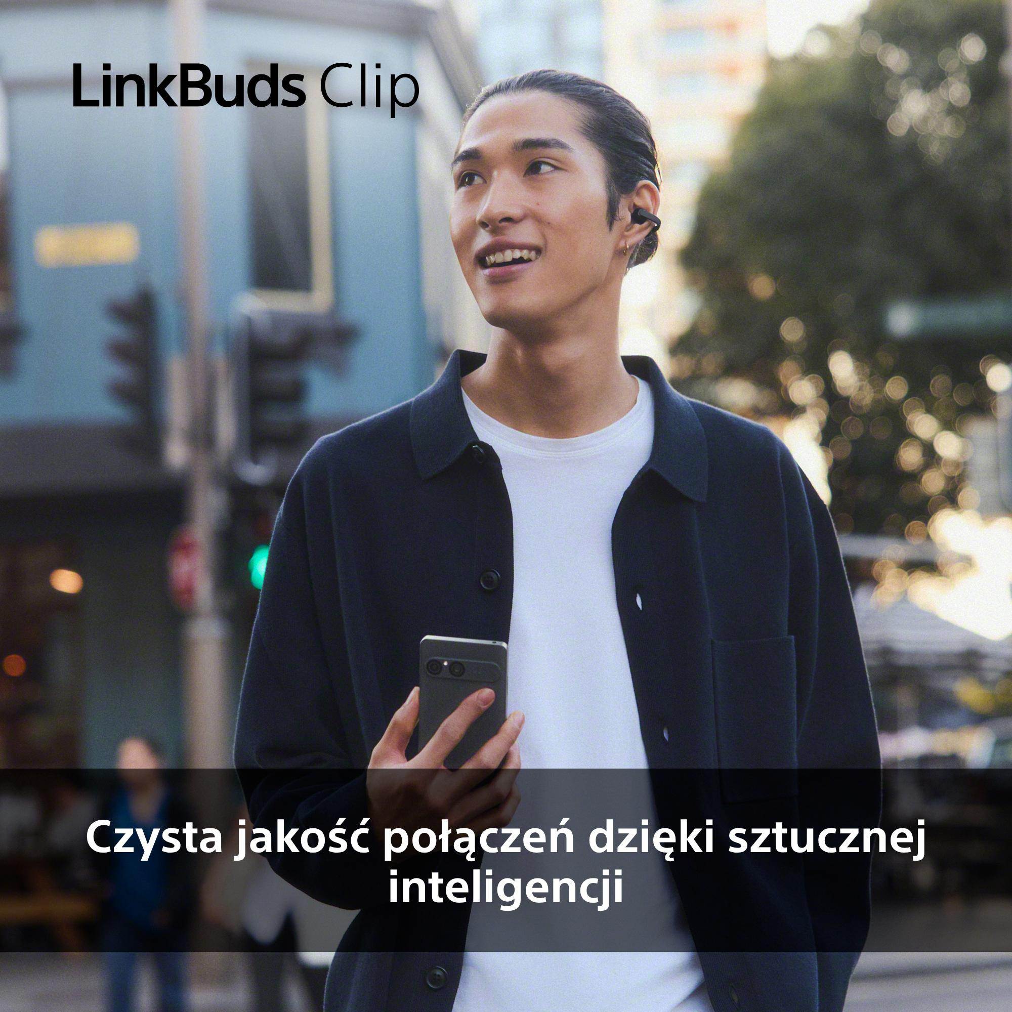 Mężczyzna ze słuchawkami i smartfonem w dłoni.