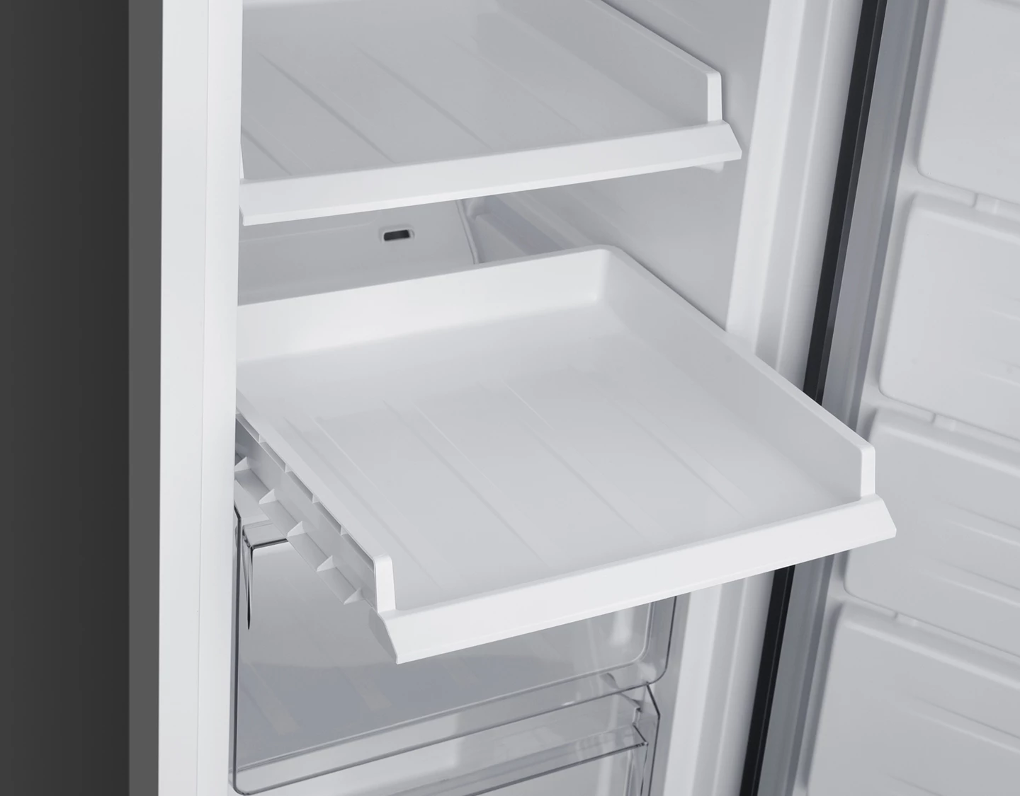 Ein leerer weißer Kühlschrank mit einem ausziehbaren Fach.