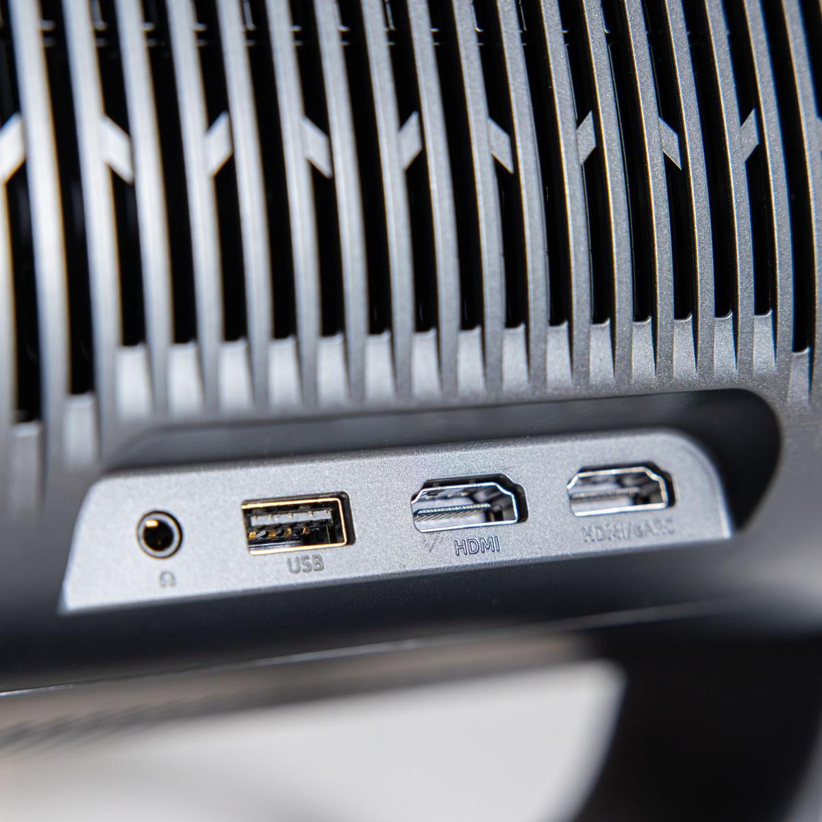 Ein silberner USB-Anschluss, ein HDMI-Anschluss und ein HDMI/ARC-Anschluss auf einem grauen Gerät.