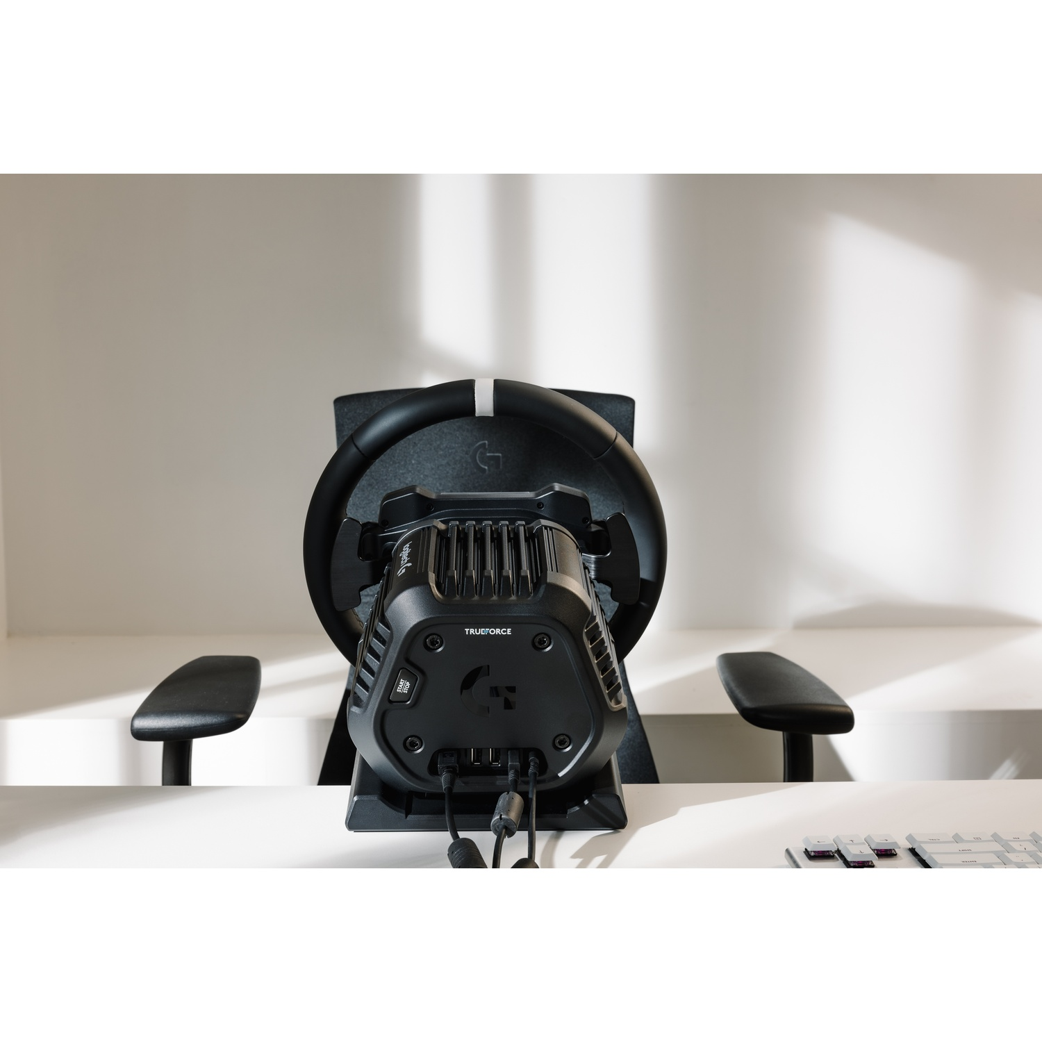 Un volante da corsa nero con logo TRUEFORCE è su una scrivania.
