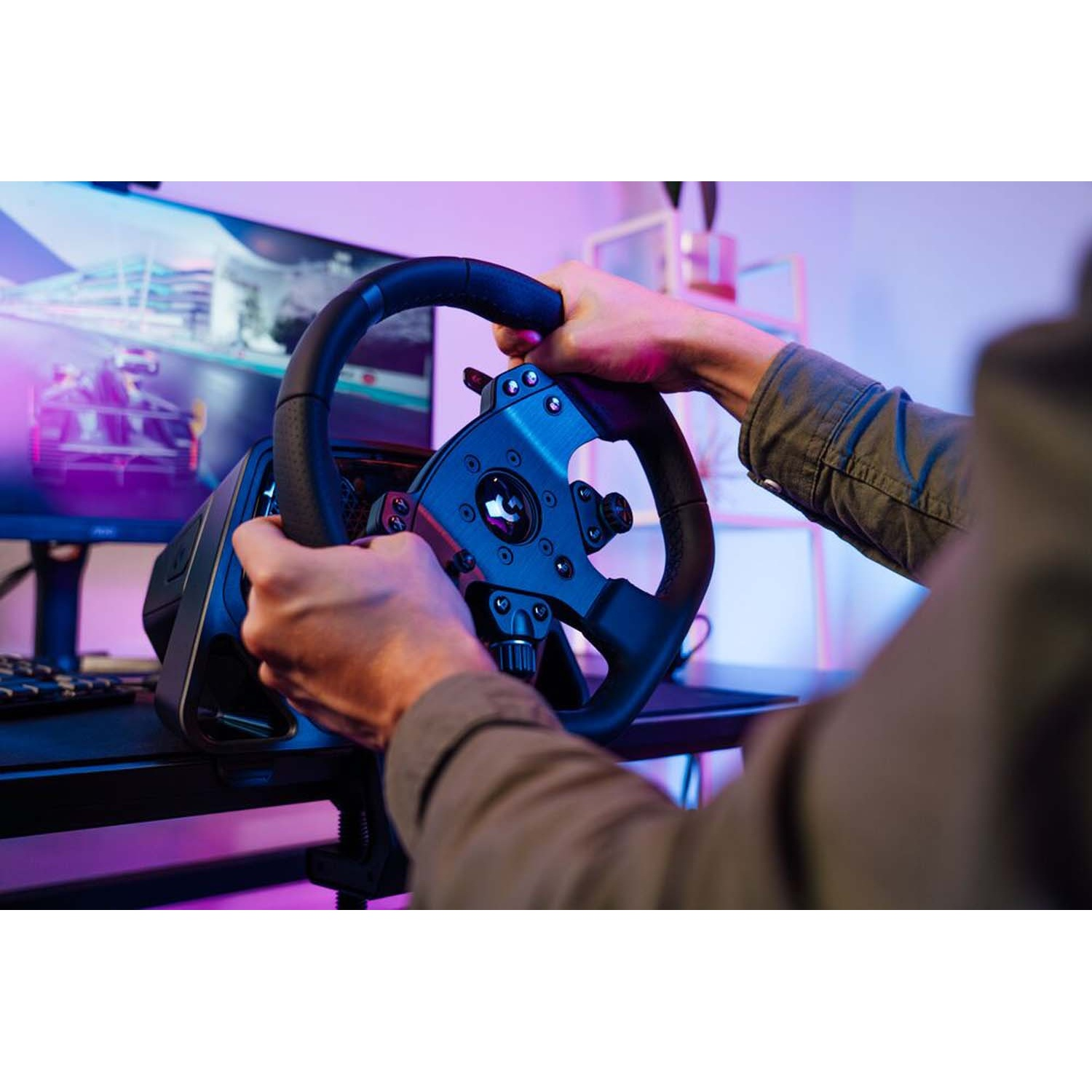 Mani impugnano un volante da corsa davanti a un monitor PC che mostra una gara d'auto.