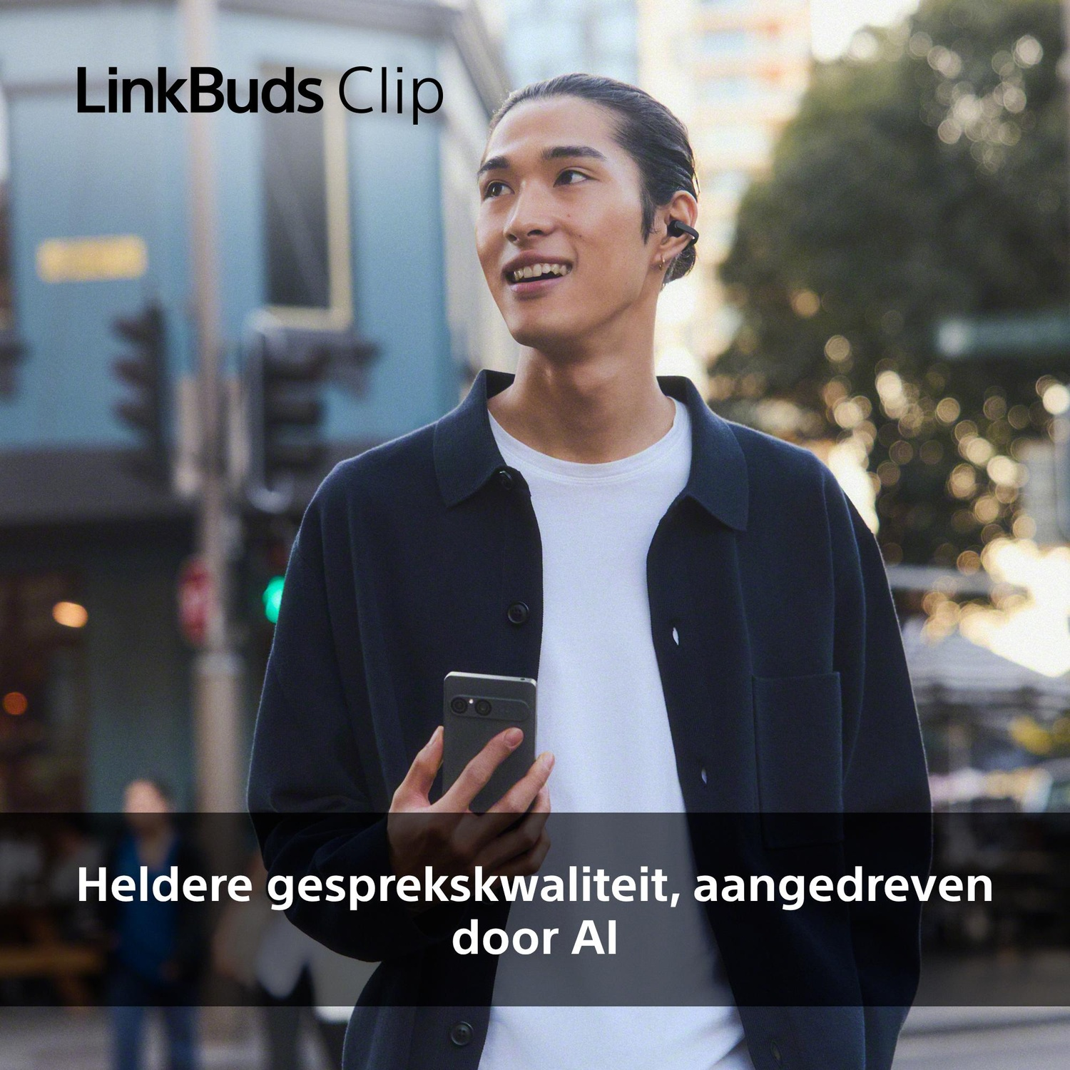 Een man met oordopjes houdt een smartphone vast.