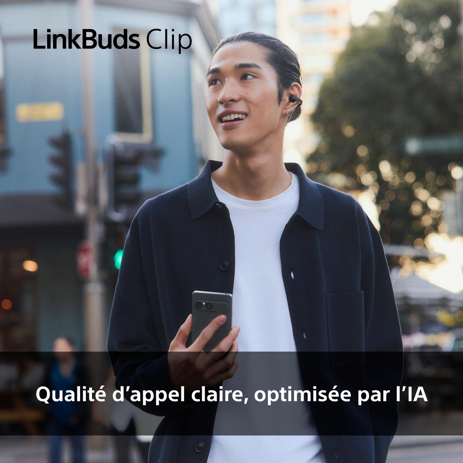 Homme avec écouteurs tient smartphone, texte LinkBuds Clip.