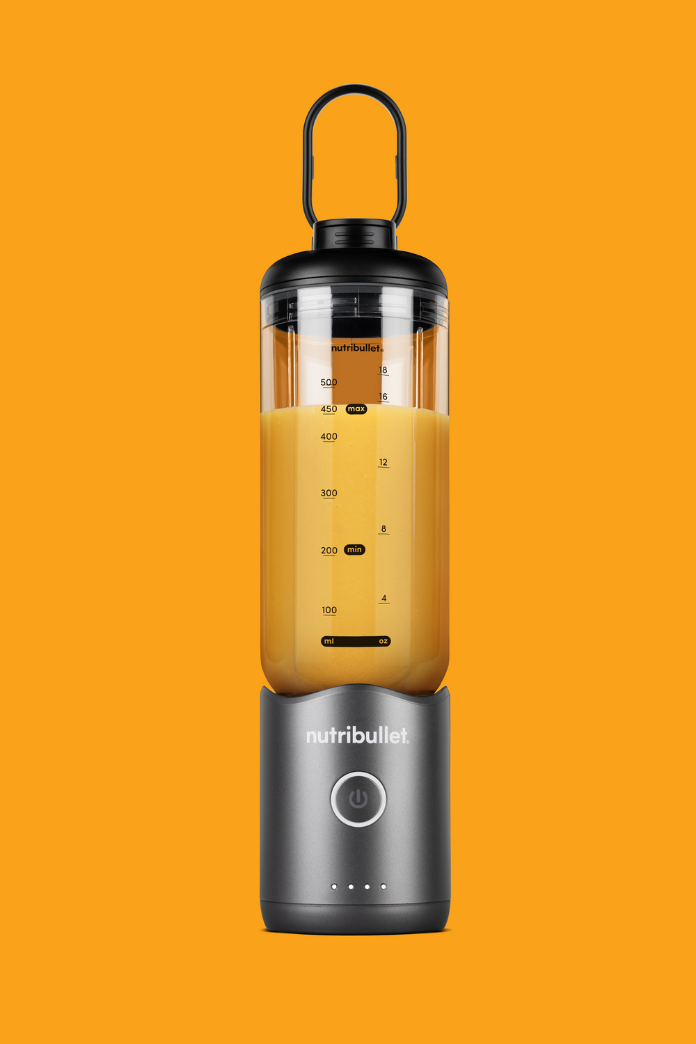 Una batidora Nutribullet portátil con jugo amarillo, sobre fondo naranja.