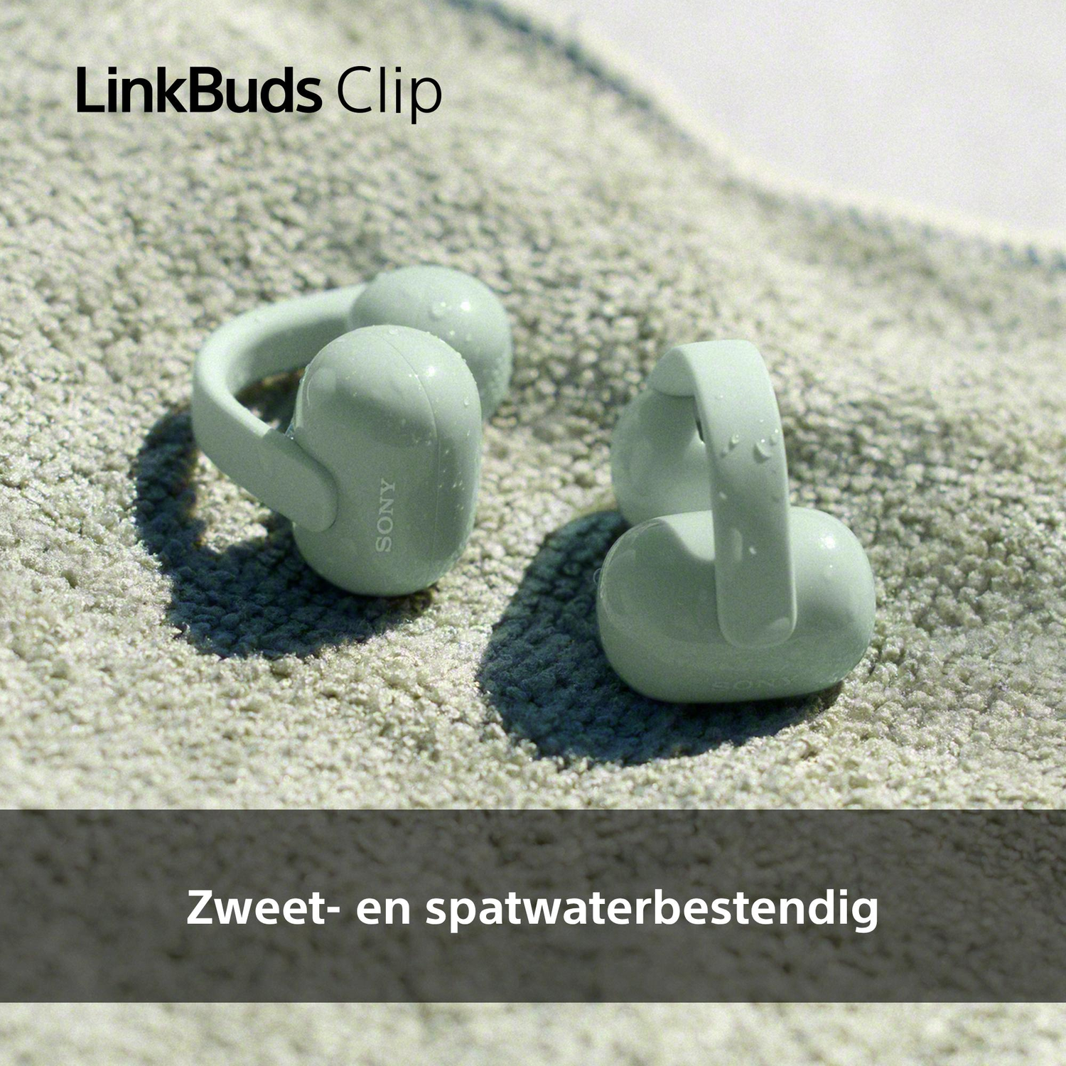 Twee lichtgroene Sony LinkBuds Clip oordopjes op een zandkleurig tapijt.