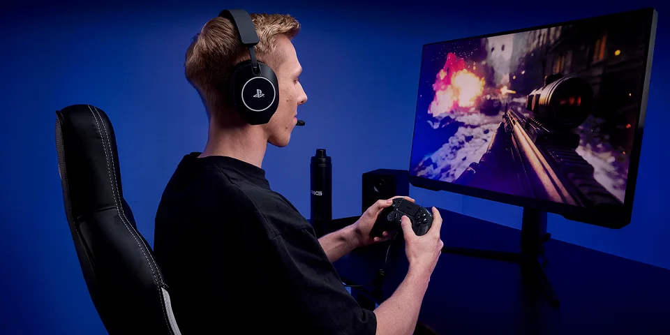 Ein Mann mit Kopfhörern spielt ein Videospiel auf einem Monitor.