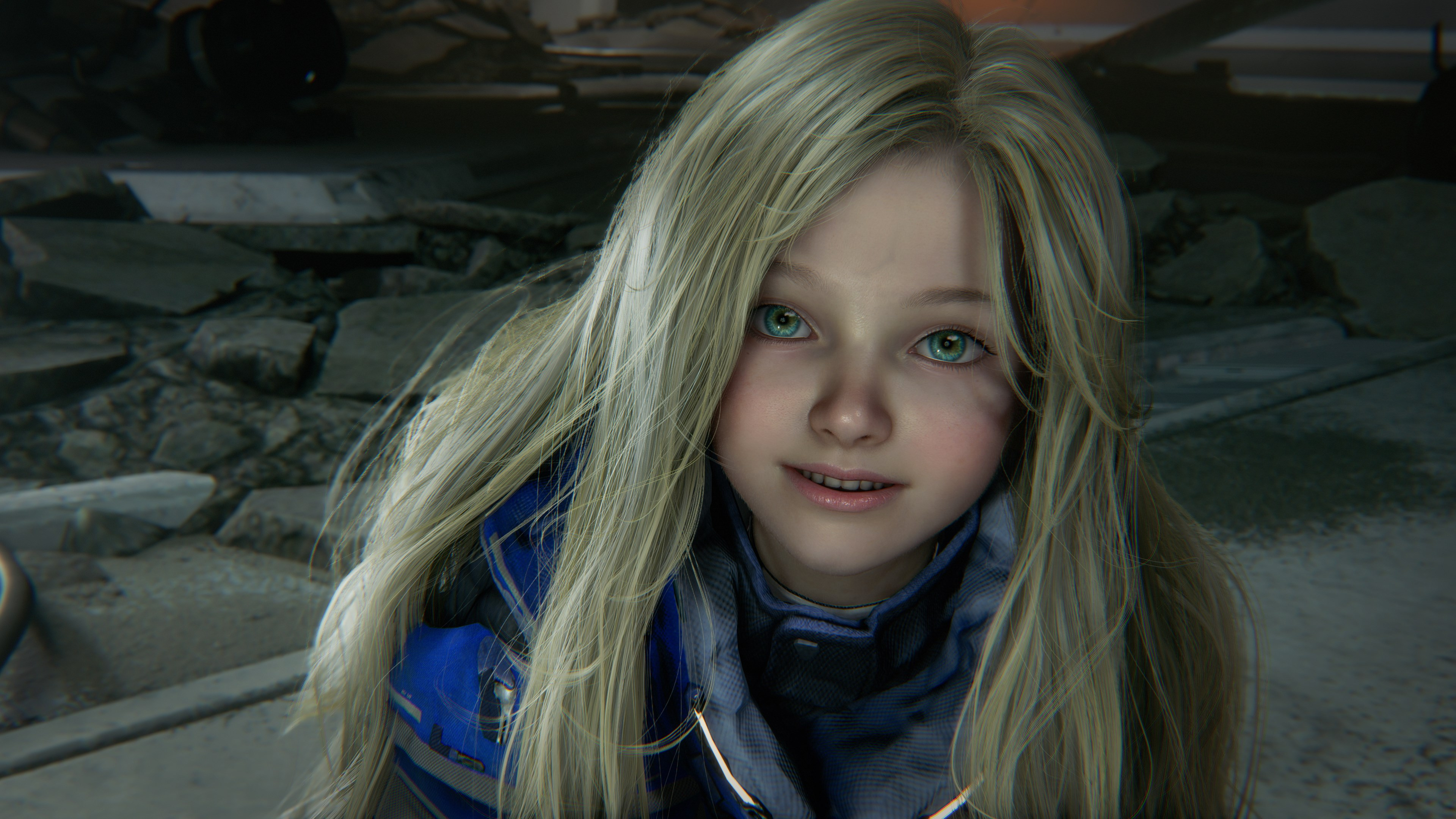 Ein junges Mädchen mit blonden Haaren und blauen Augen trägt eine blaue Jacke.