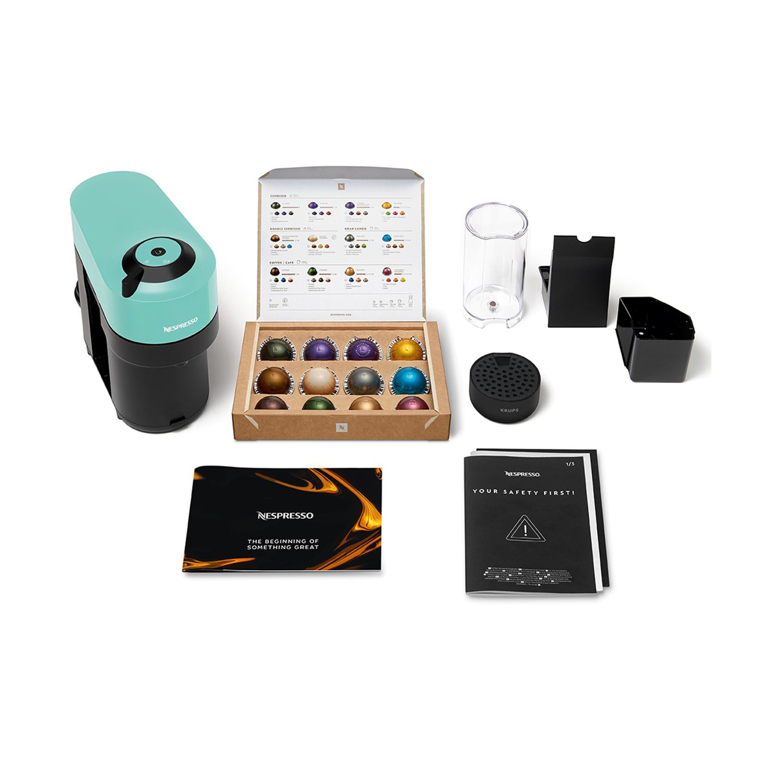 Macchina Nespresso color turchese con capsule, accessori e manuali.