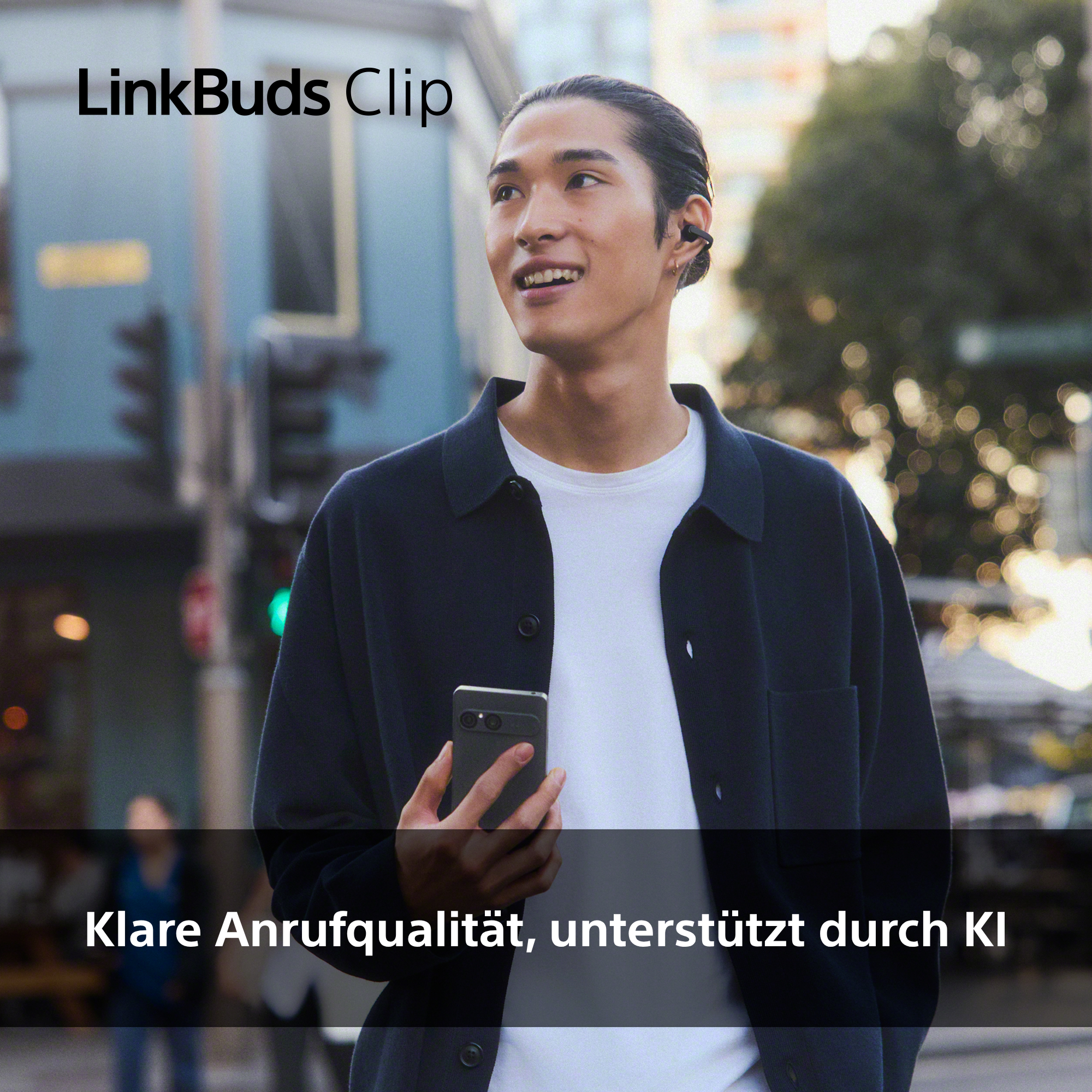 Mann mit Ohrhörern und Smartphone auf der Straße.