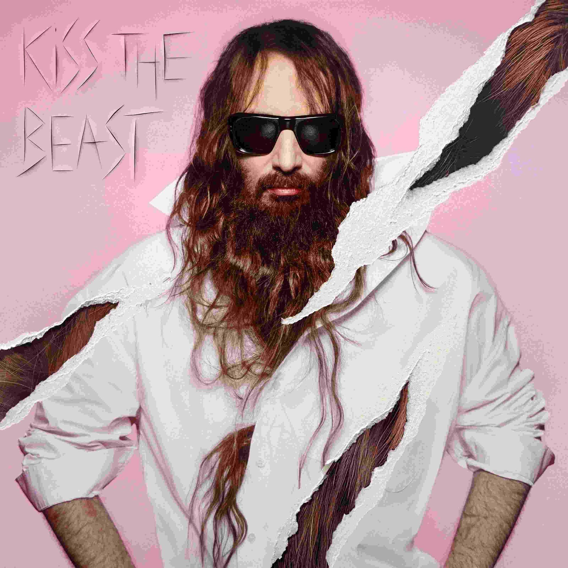 Homme aux cheveux longs, barbe, lunettes de soleil, chemise blanche, sur fond rose.